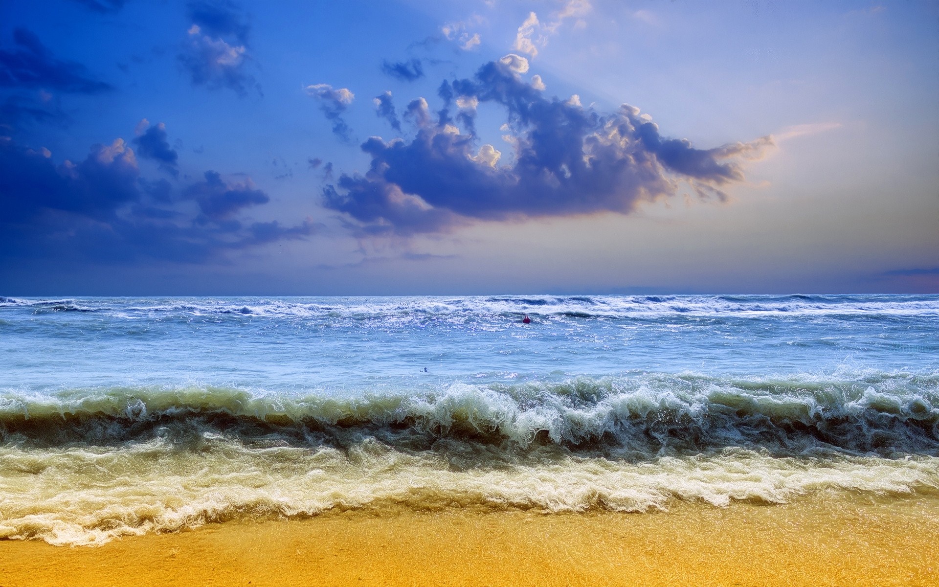 Ocean waves crashing on a sandy beach at sunset HD Wallpaper