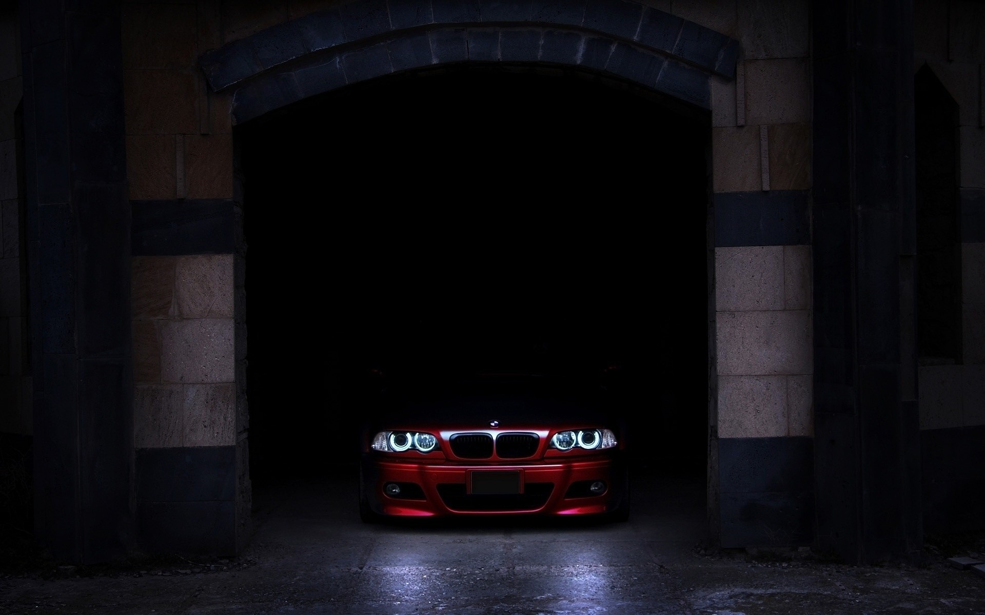 Red BMW car parked in a dark stone archway HD Wallpaper