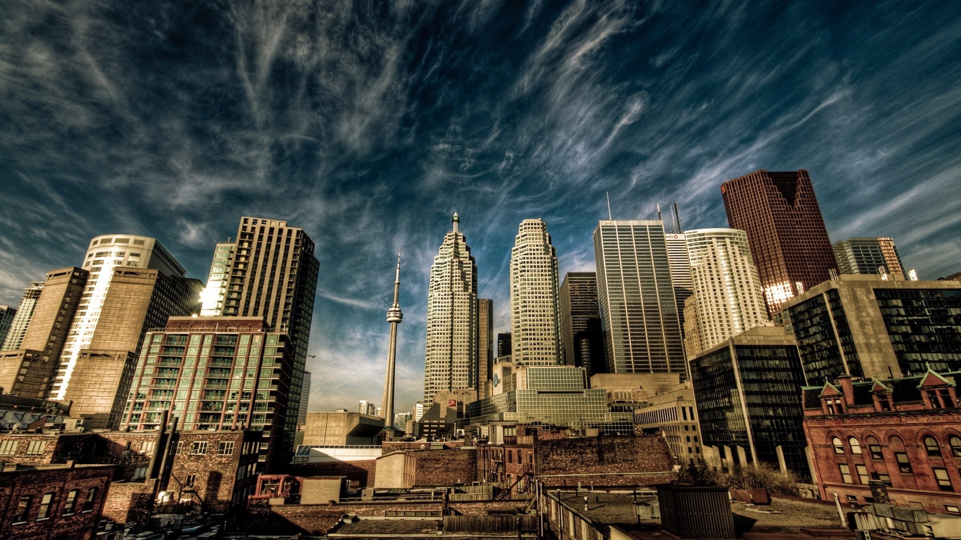 Toronto cityscape with CN Tower and skyscrapers under cloudy sky HD Wallpaper