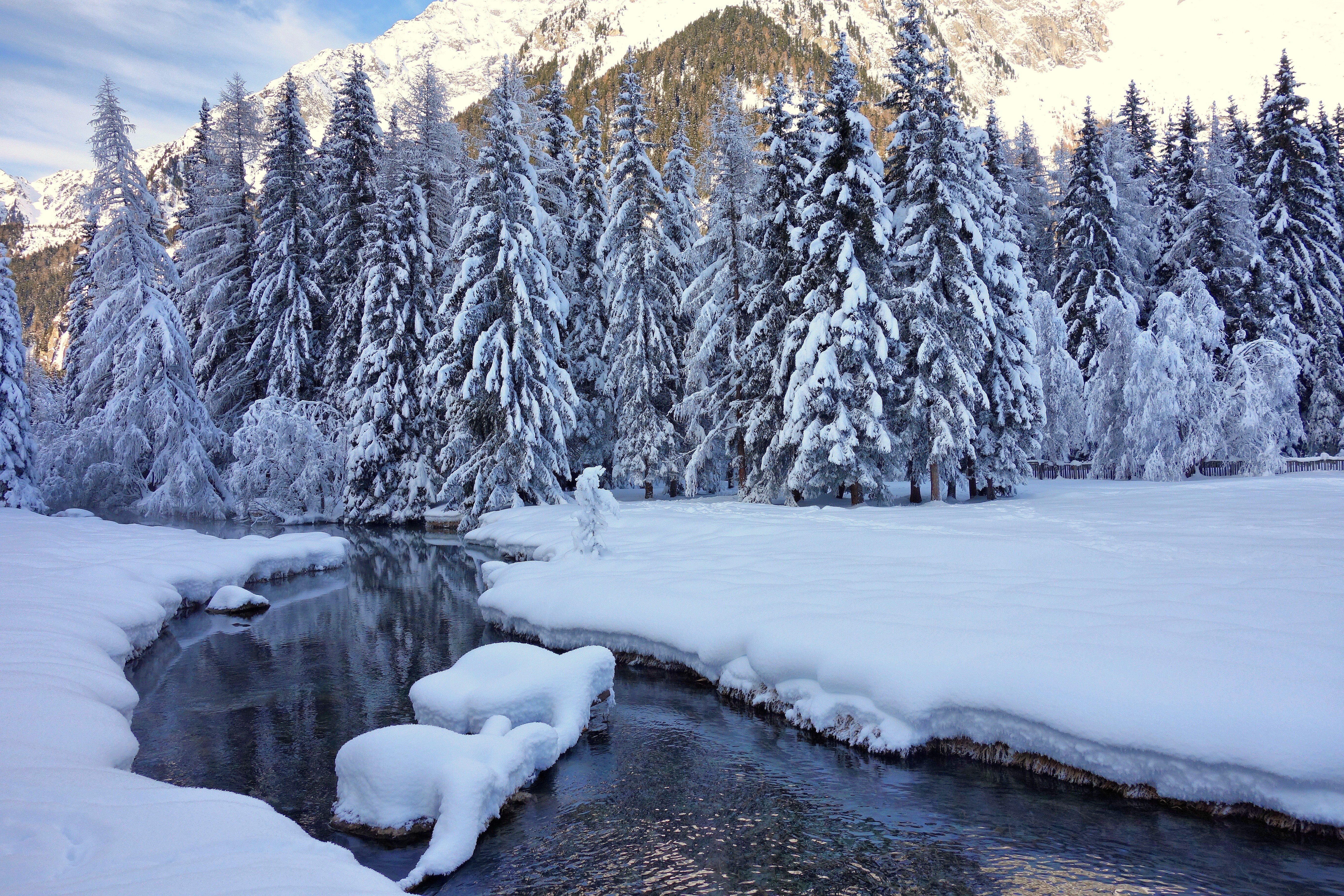 Snowy forest with a stream and mountains HD Wallpaper