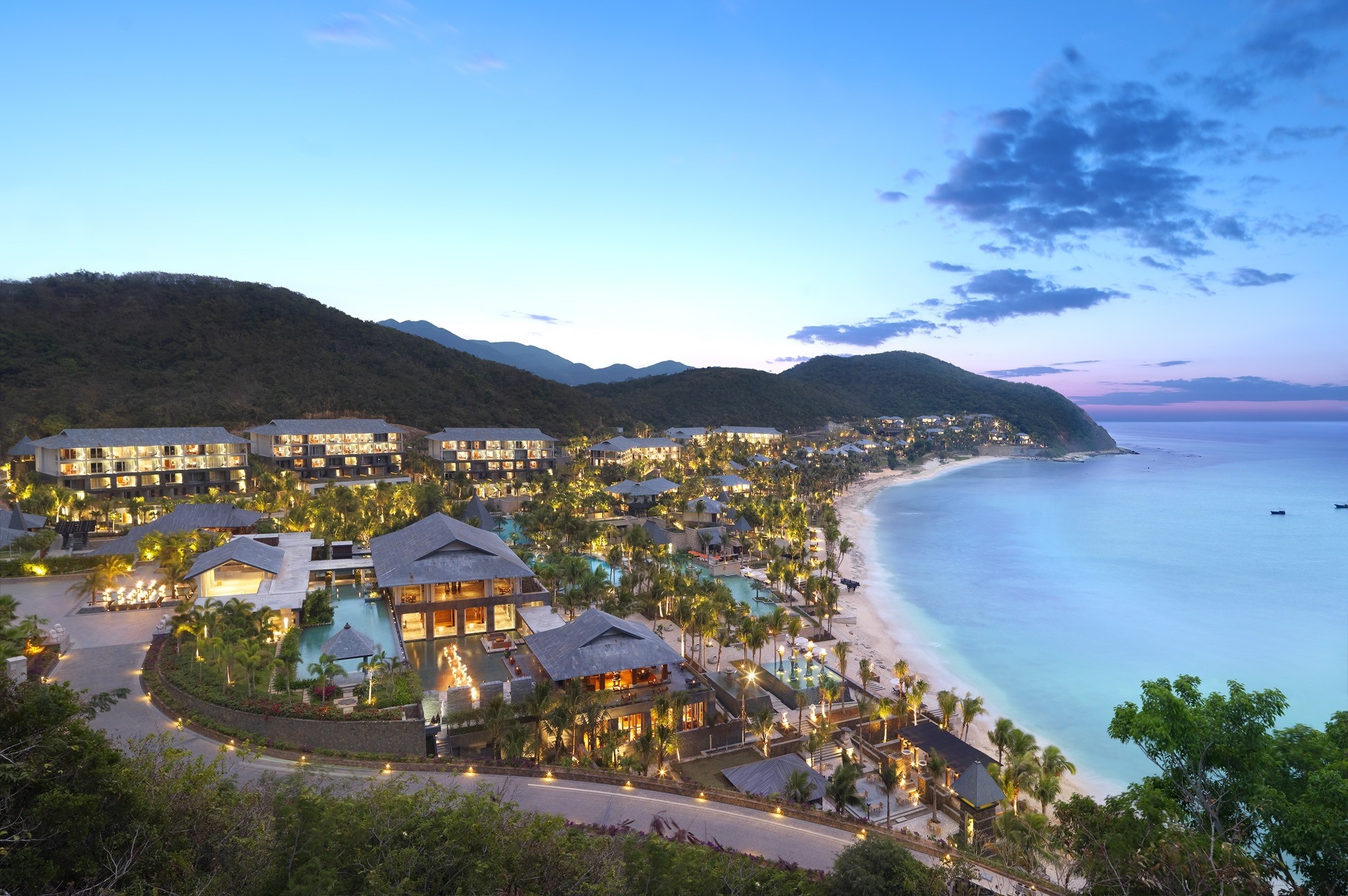 Resort on a tropical bay with mountains in the background HD Wallpaper