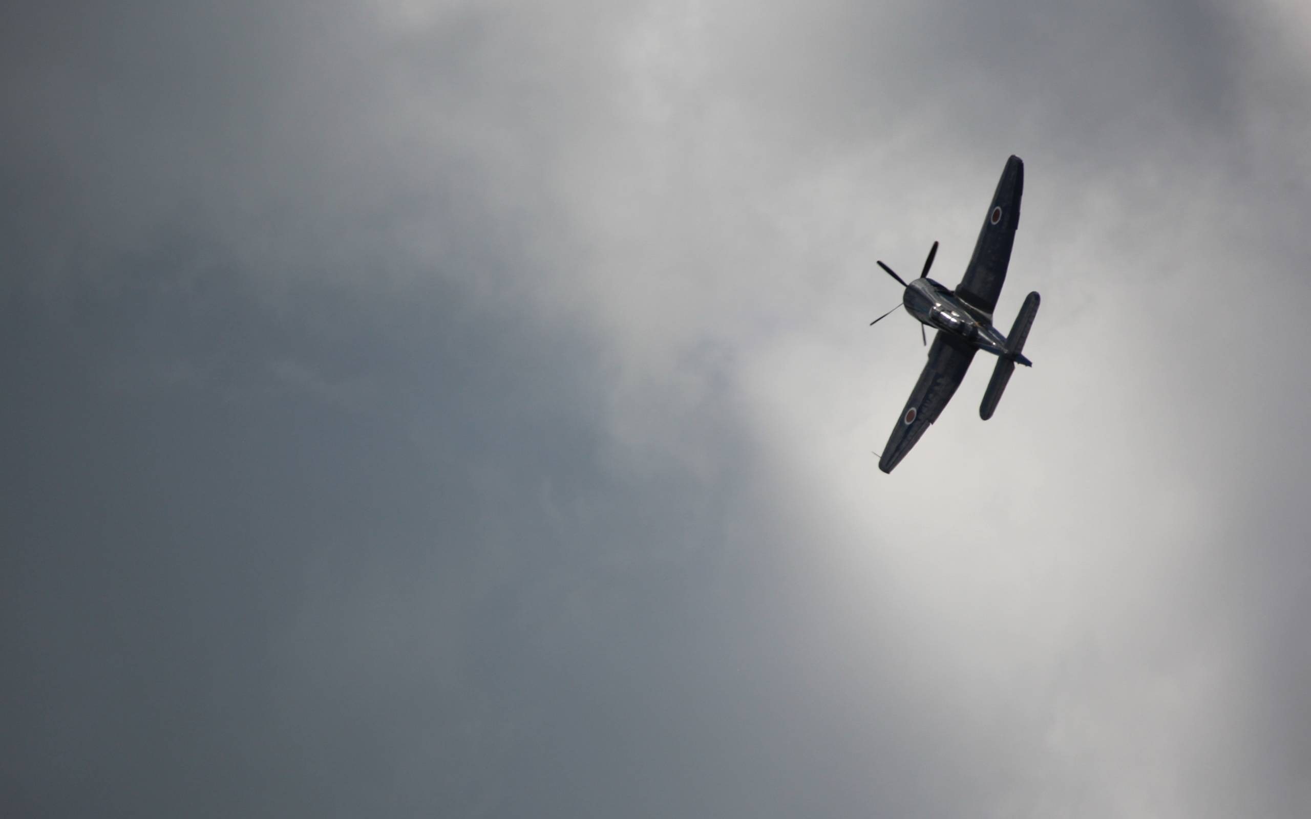 Dark airplane with propeller flying in cloudy sky HD Wallpaper