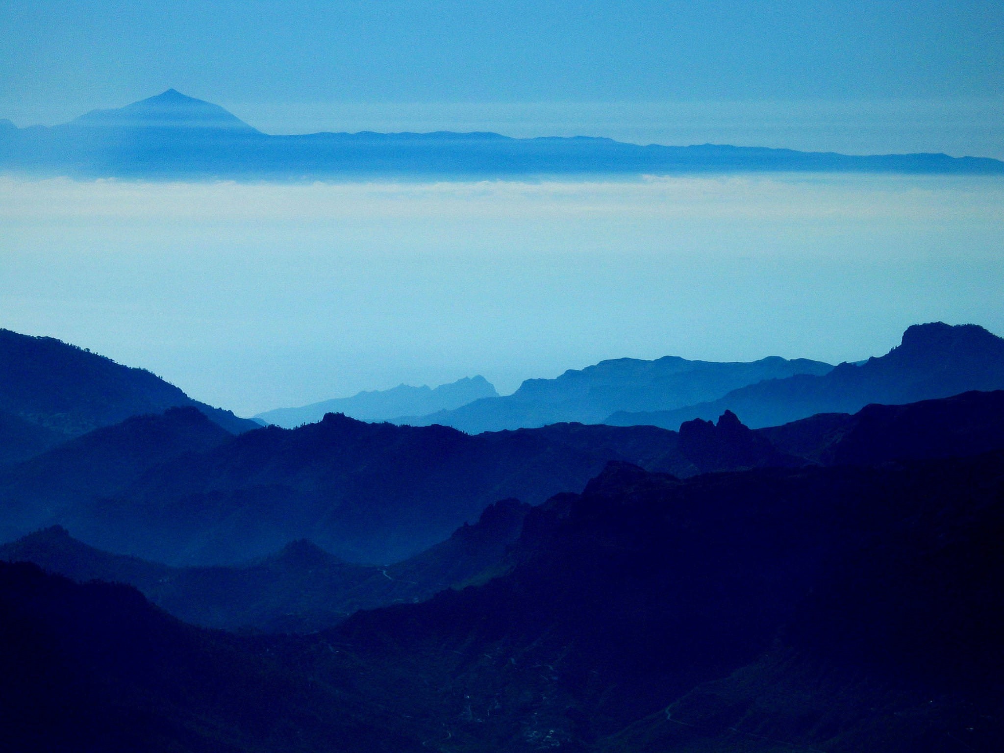 Mountain range with distant peak and clouds HD Wallpaper