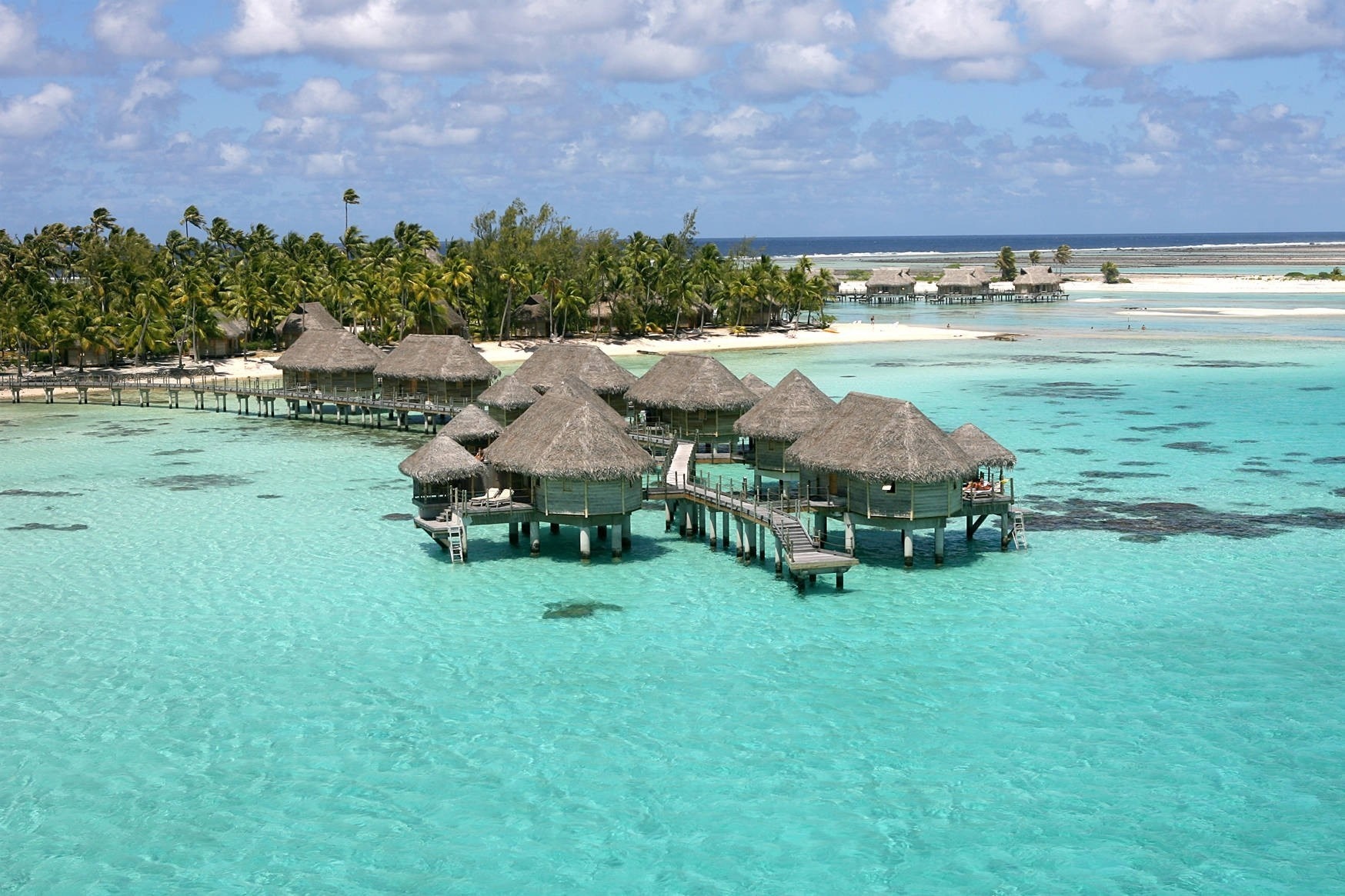Overwater bungalows in a tropical turquoise lagoon HD Wallpaper