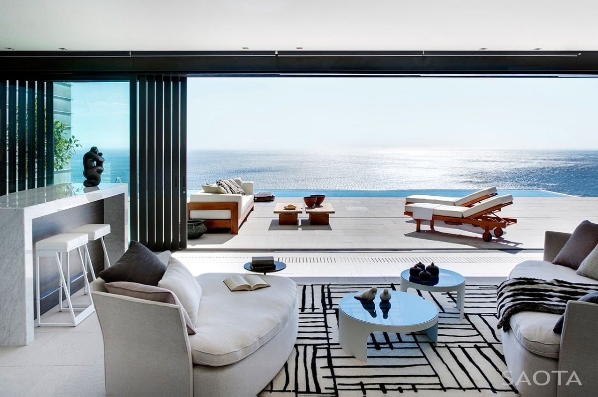 Modern living room with ocean view and outdoor seating HD Wallpaper
