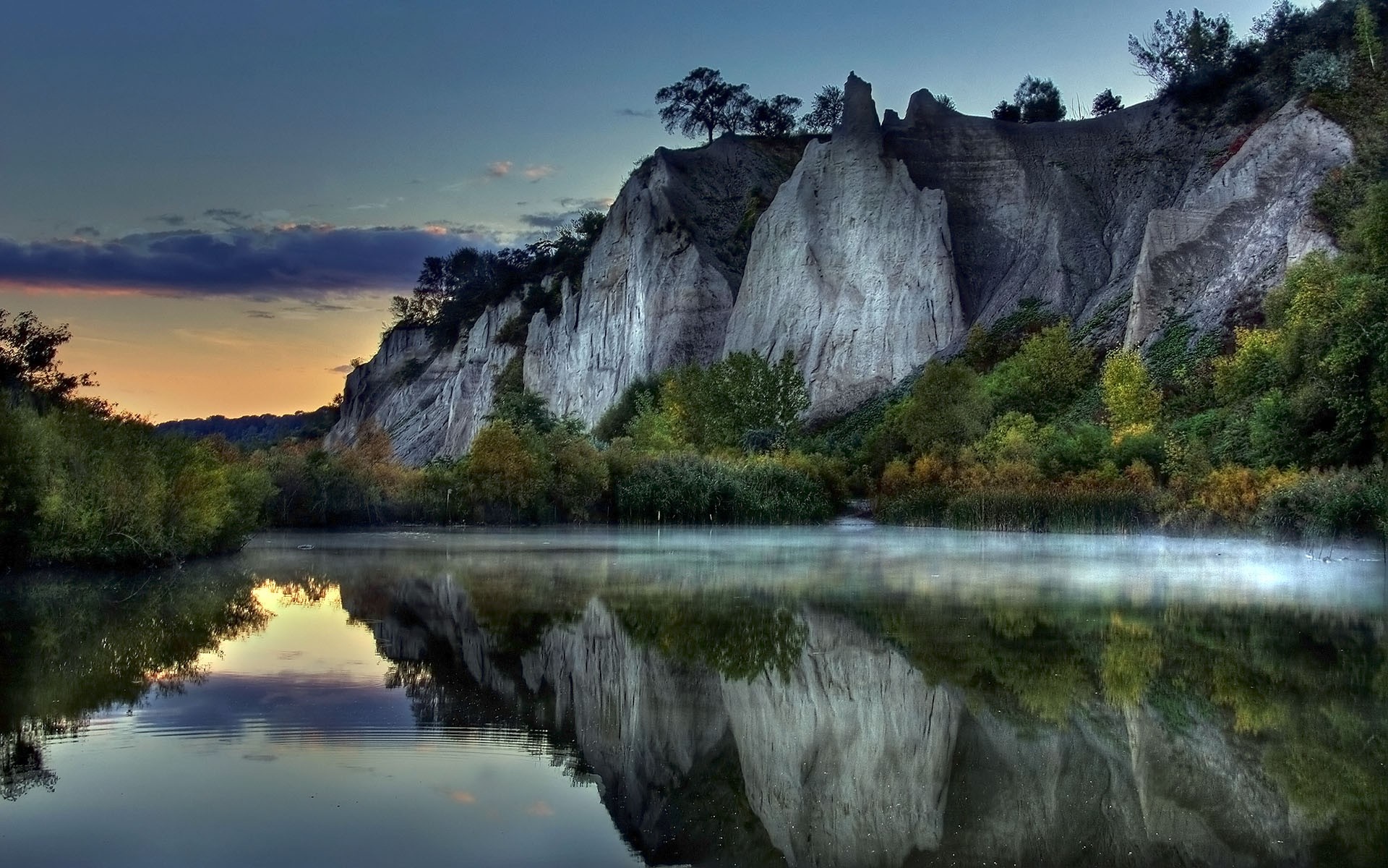 Cliffside reflection in a misty lake at sunrise HD Wallpaper