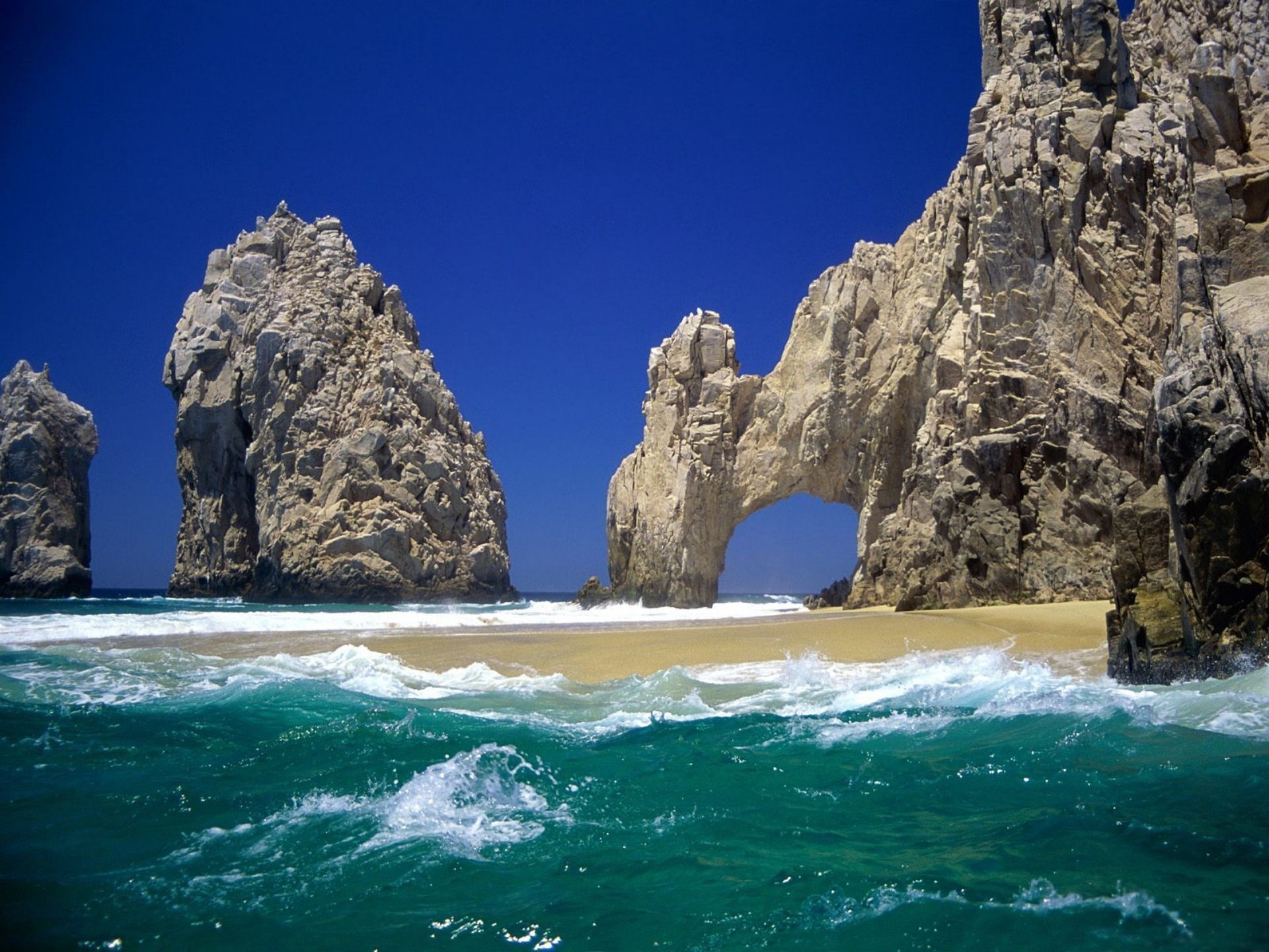 Rocky coast with arch and turquoise ocean waves HD Wallpaper