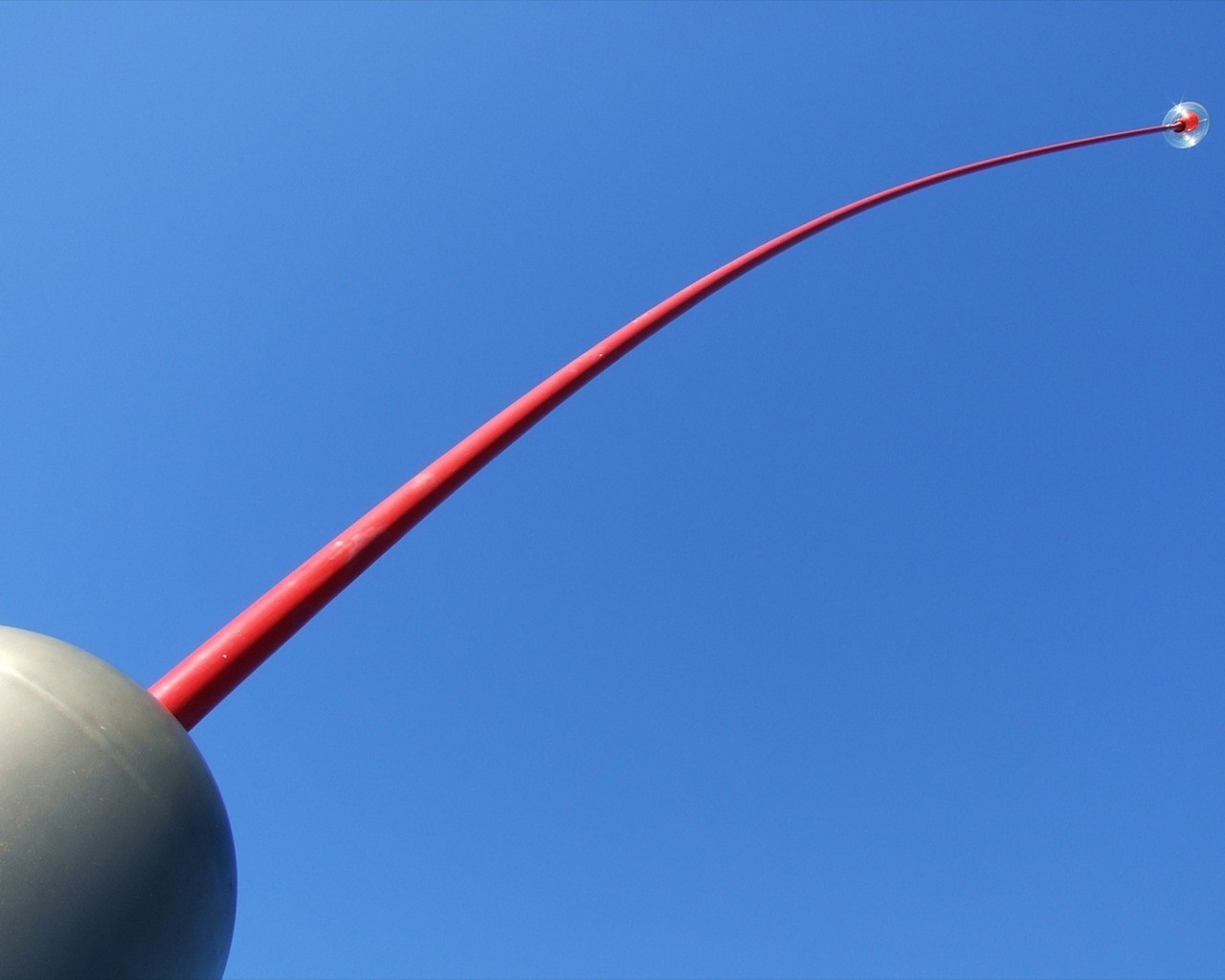 Red antenna with a clear sphere on top against blue sky HD Wallpaper