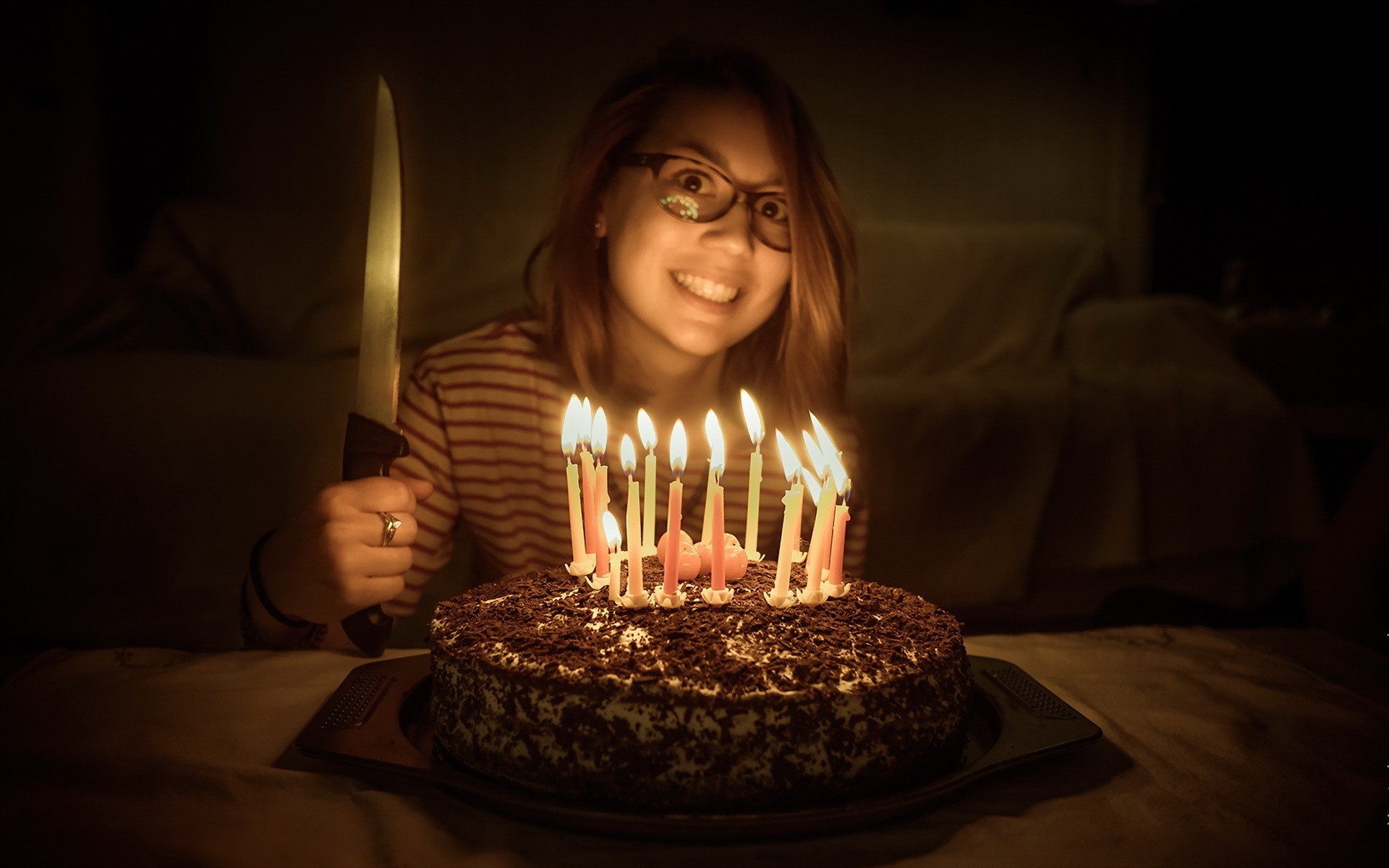Woman holding knife near birthday cake with candles HD Wallpaper