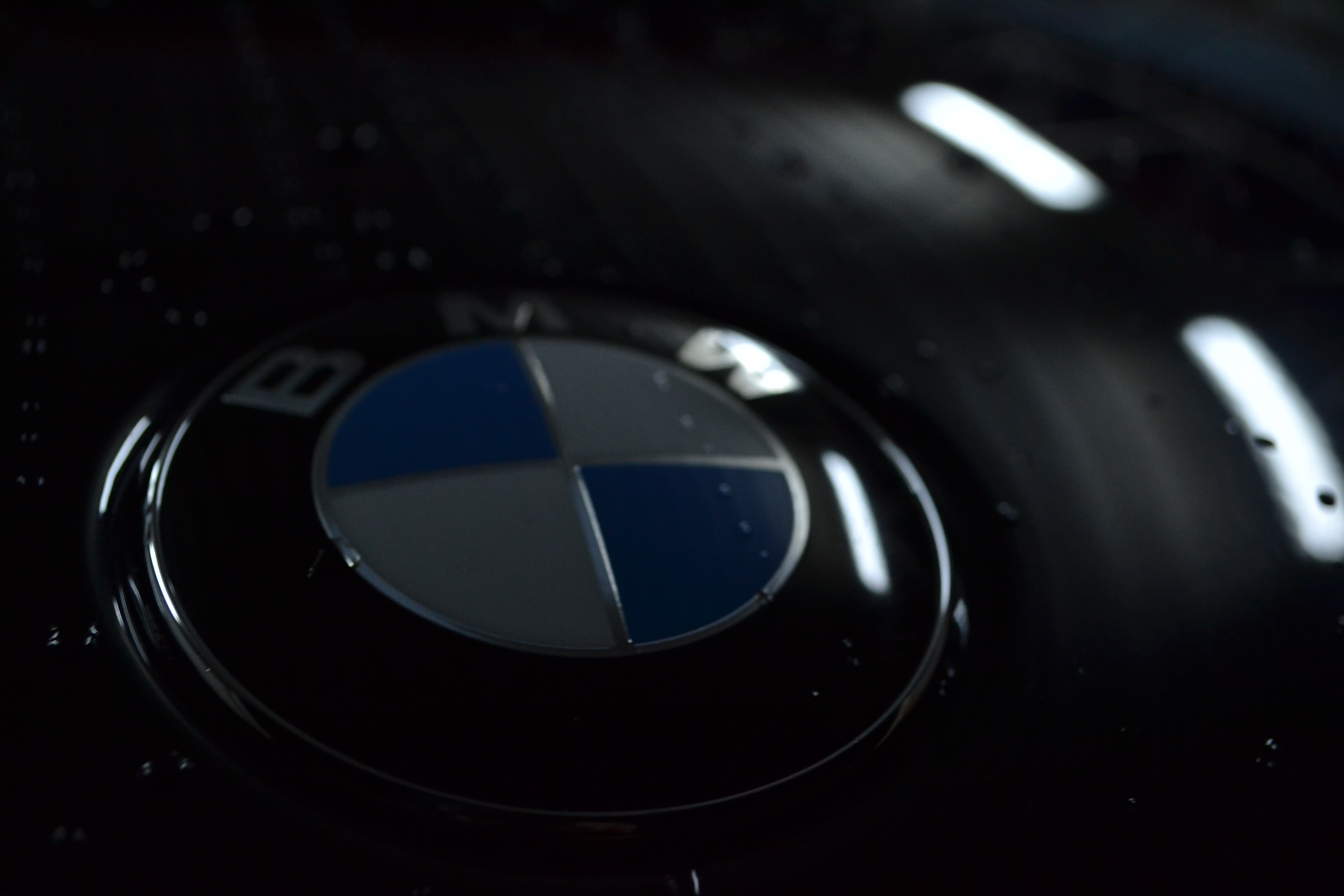 BMW logo on a black car with water droplets HD Wallpaper