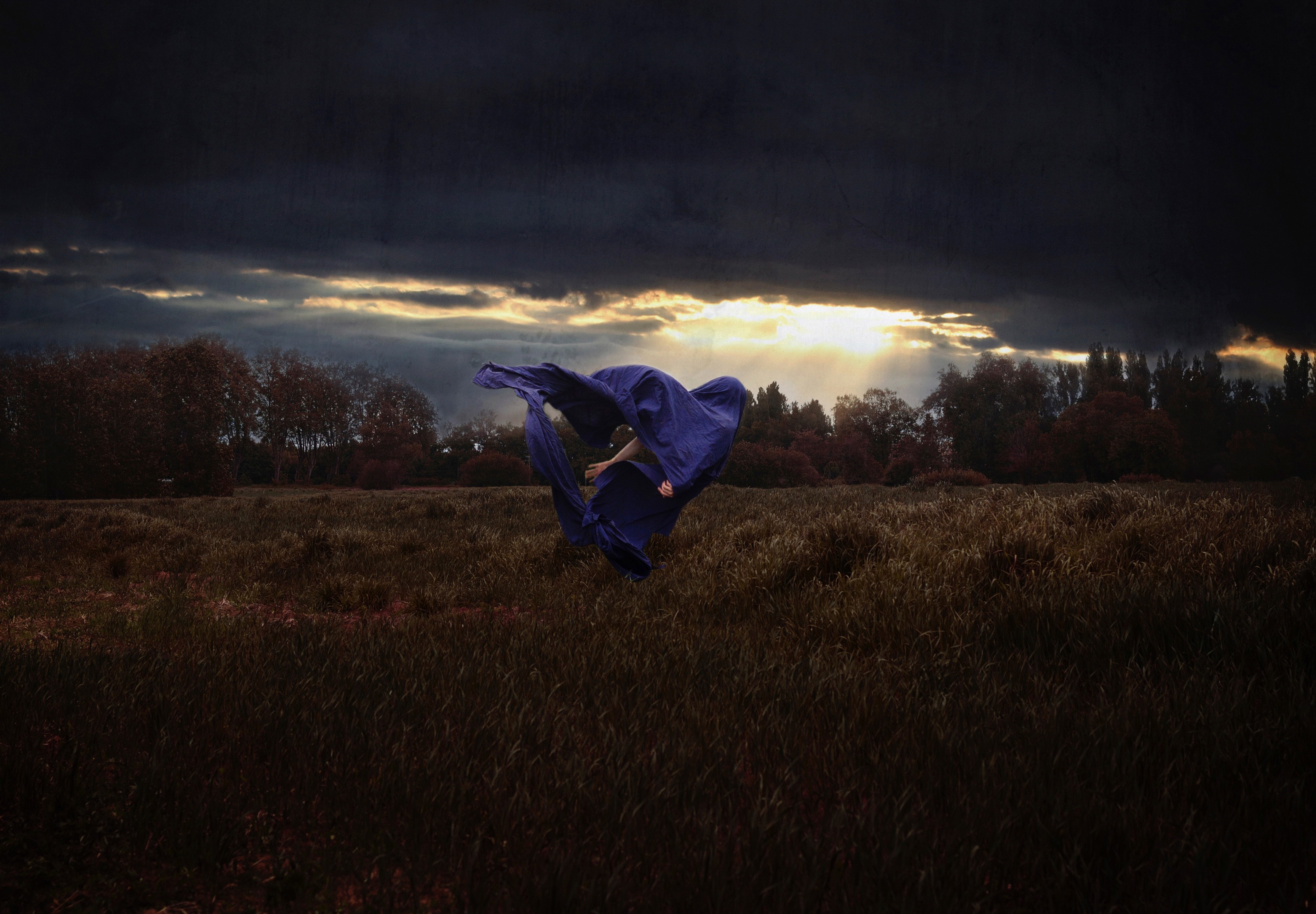Woman in blue fabric in a field at sunset HD Wallpaper