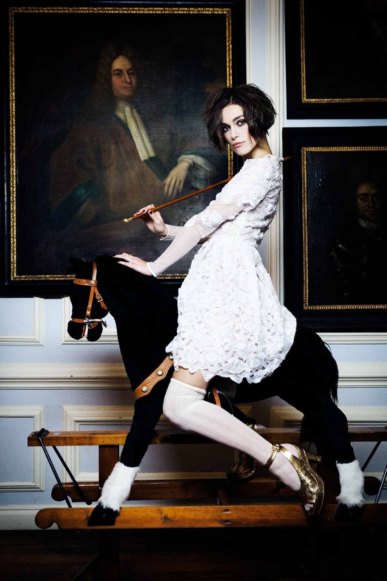Keira Knightley on a rocking horse in front of paintings HD Wallpaper