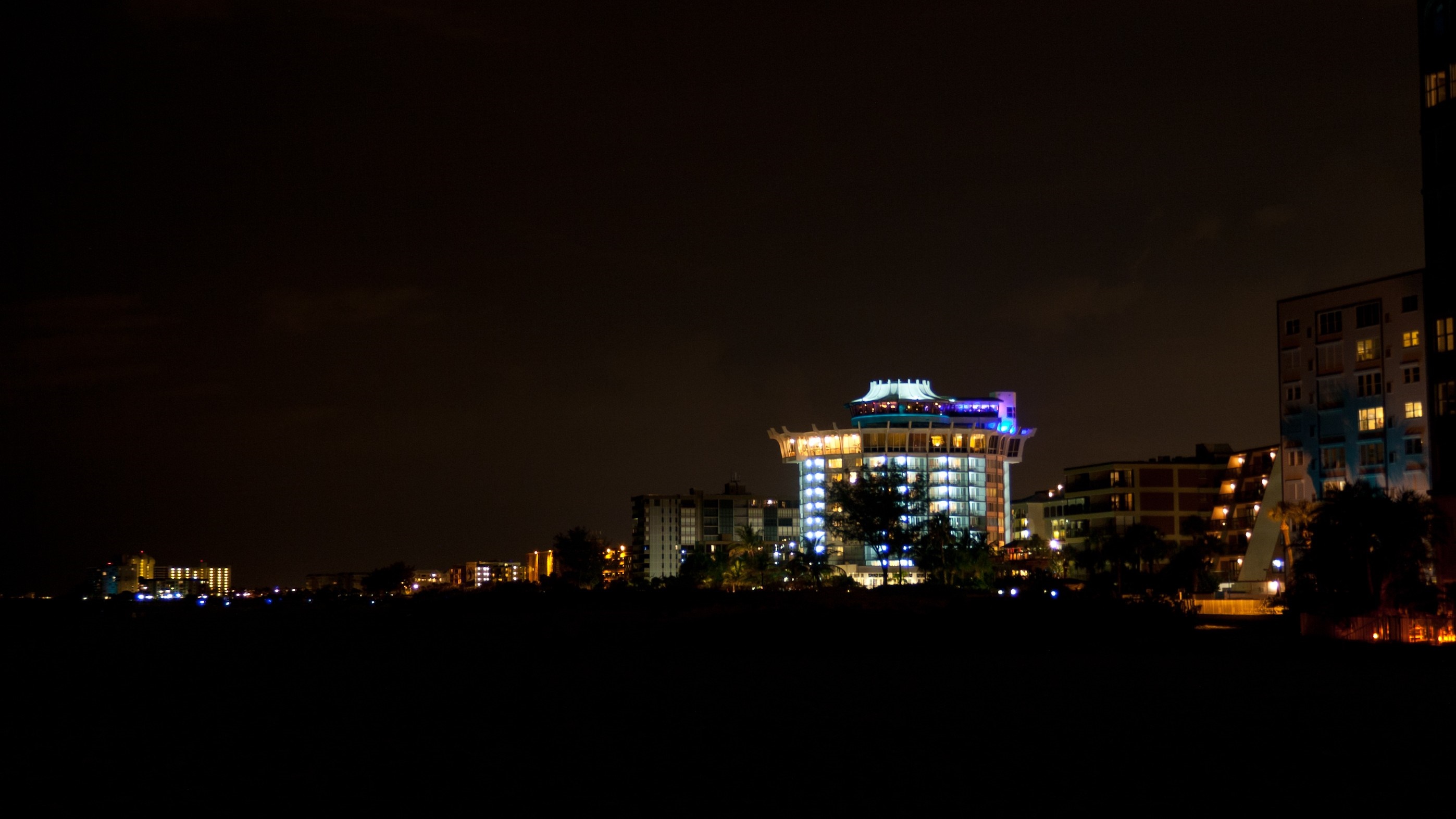 Cityscape at night with illuminated buildings HD Wallpaper