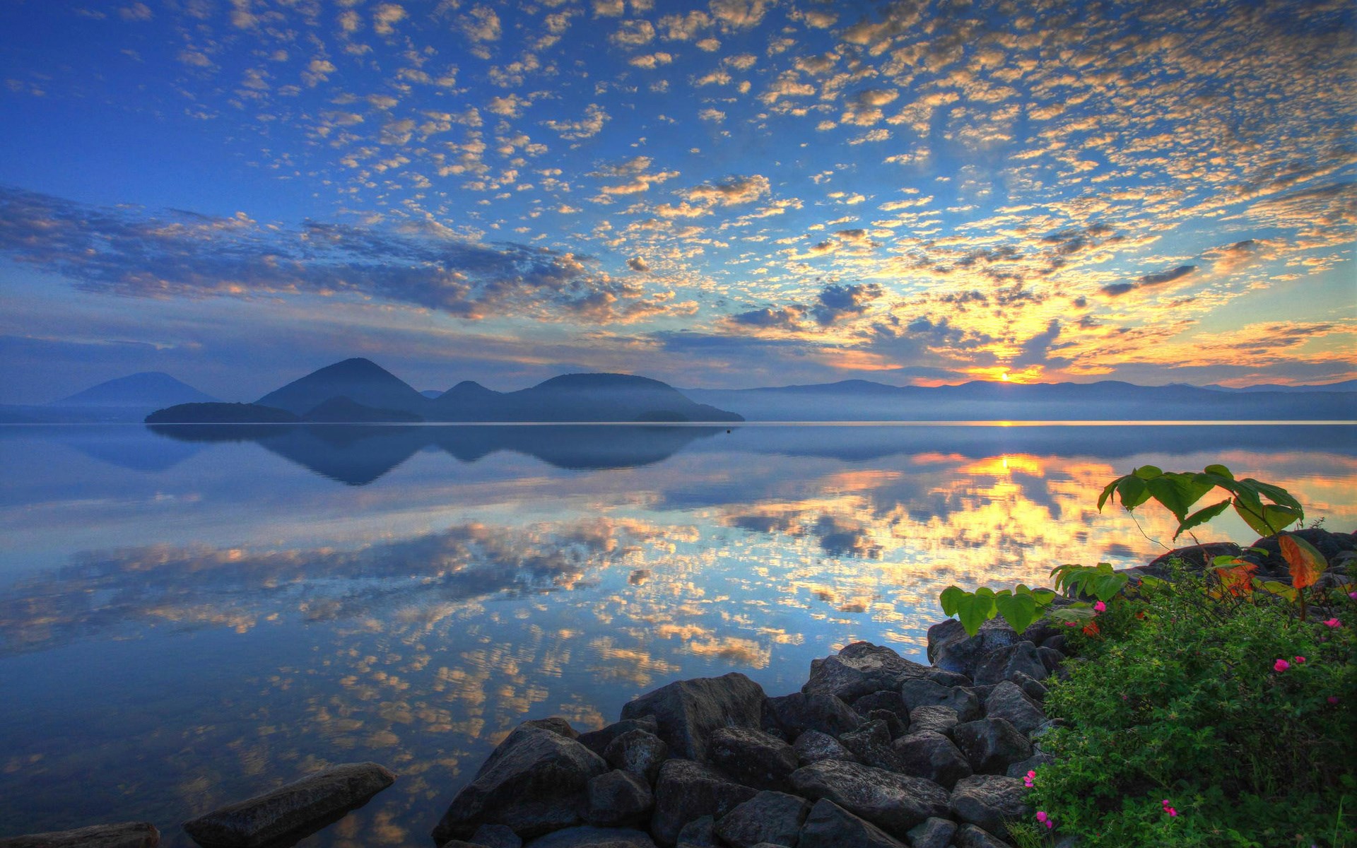 Sunrise over a calm lake with mountains and clouds HD Wallpaper