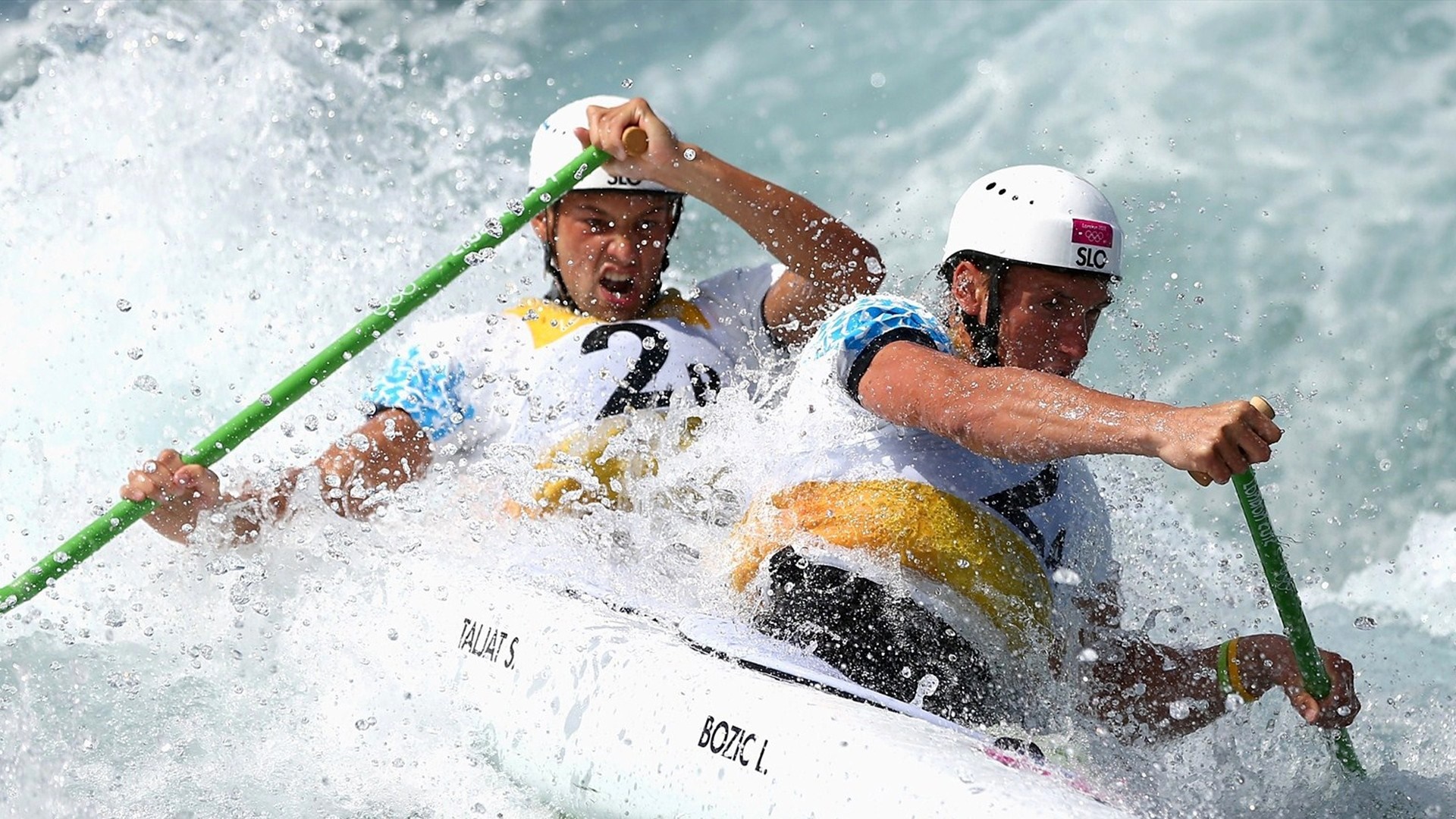 Two men in a canoe navigating whitewater rapids HD Wallpaper