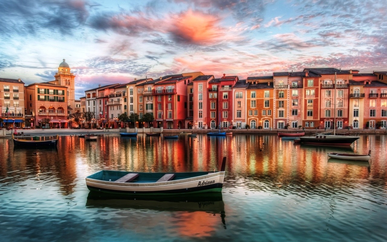 Colorful buildings reflected in a canal with boats at dusk HD Wallpaper