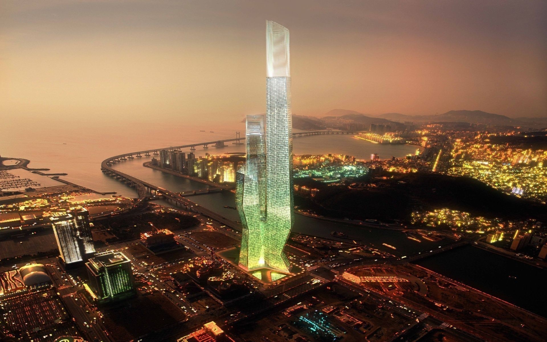 Aerial view of a modern city skyline at dusk with a prominent skyscraper HD Wallpaper