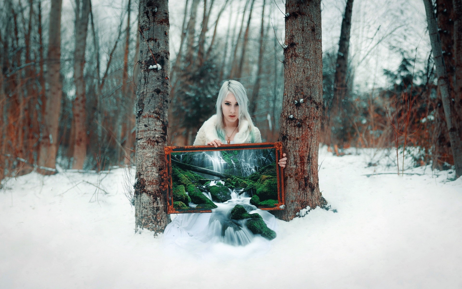 Woman holding a framed waterfall in a snowy forest HD Wallpaper