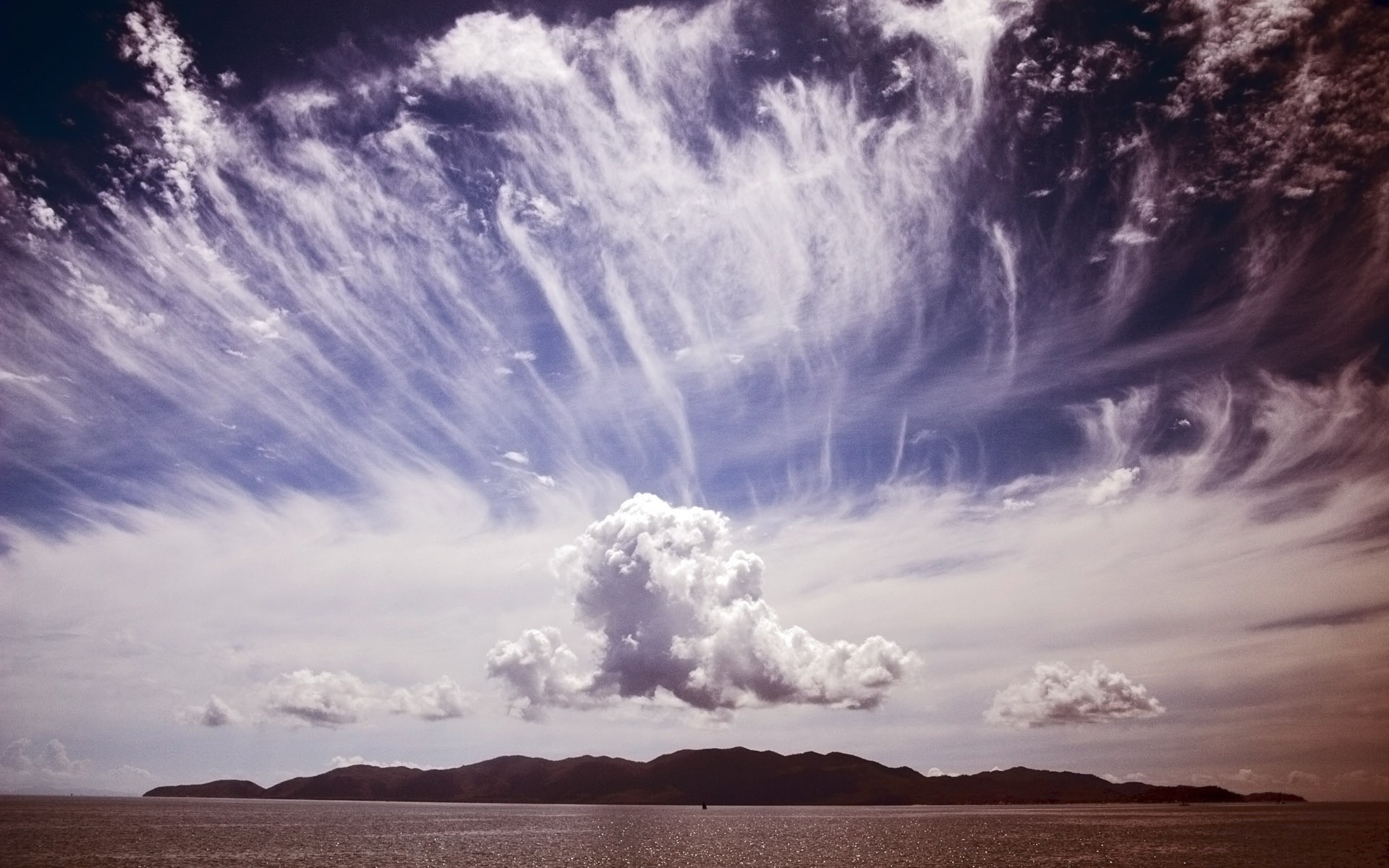 Dramatic clouds over a distant island and the sea HD Wallpaper