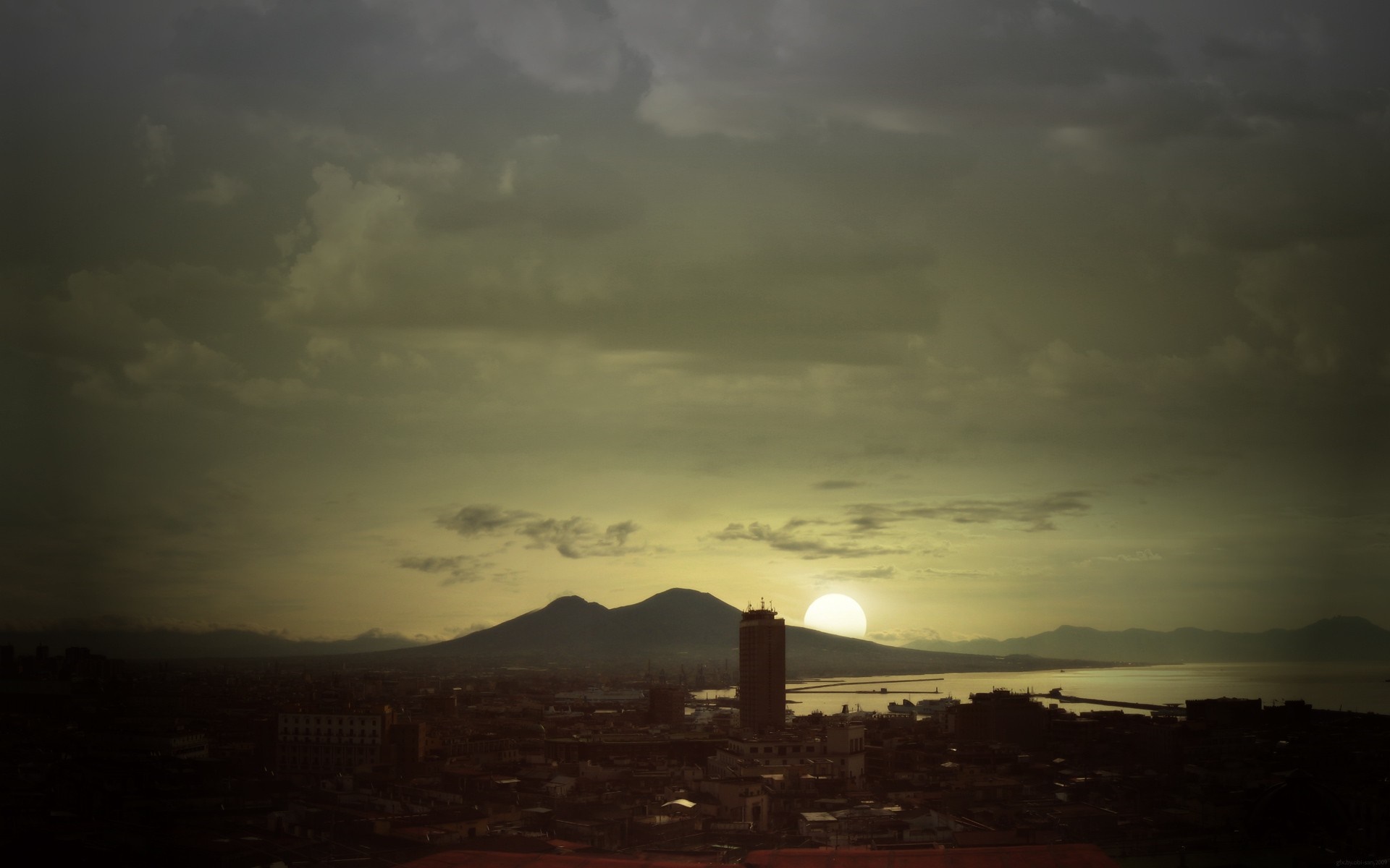 Sunset over a cityscape with mountains and sea HD Wallpaper