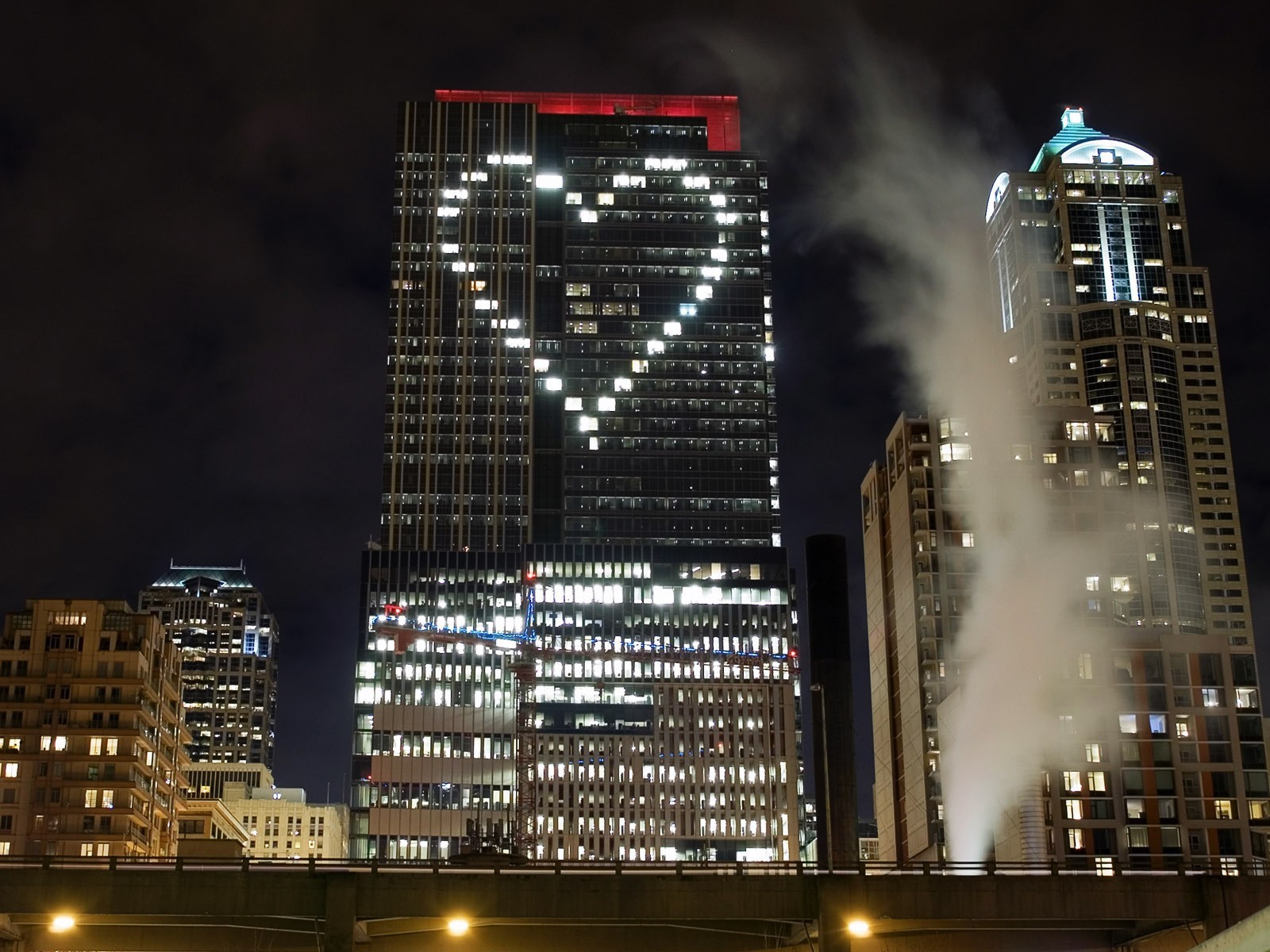Cityscape at night with heart-shaped lights on skyscraper HD Wallpaper