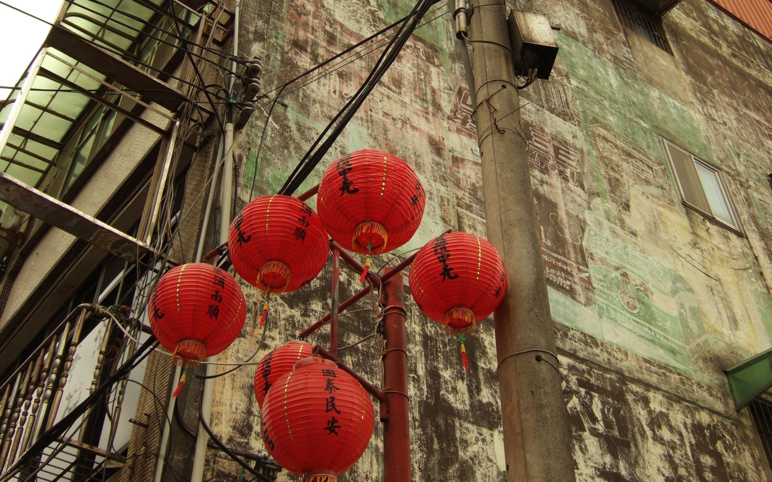 Red lanterns hanging in front of an old building HD Wallpaper