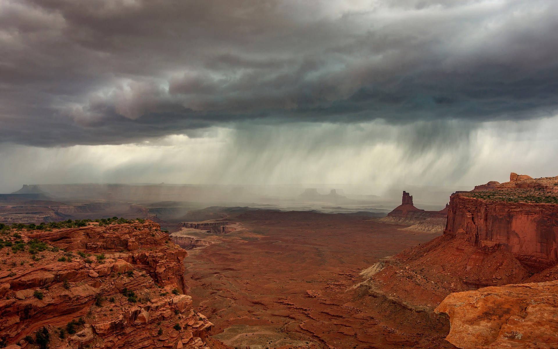 Stormy skies over a desert canyon landscape HD Wallpaper