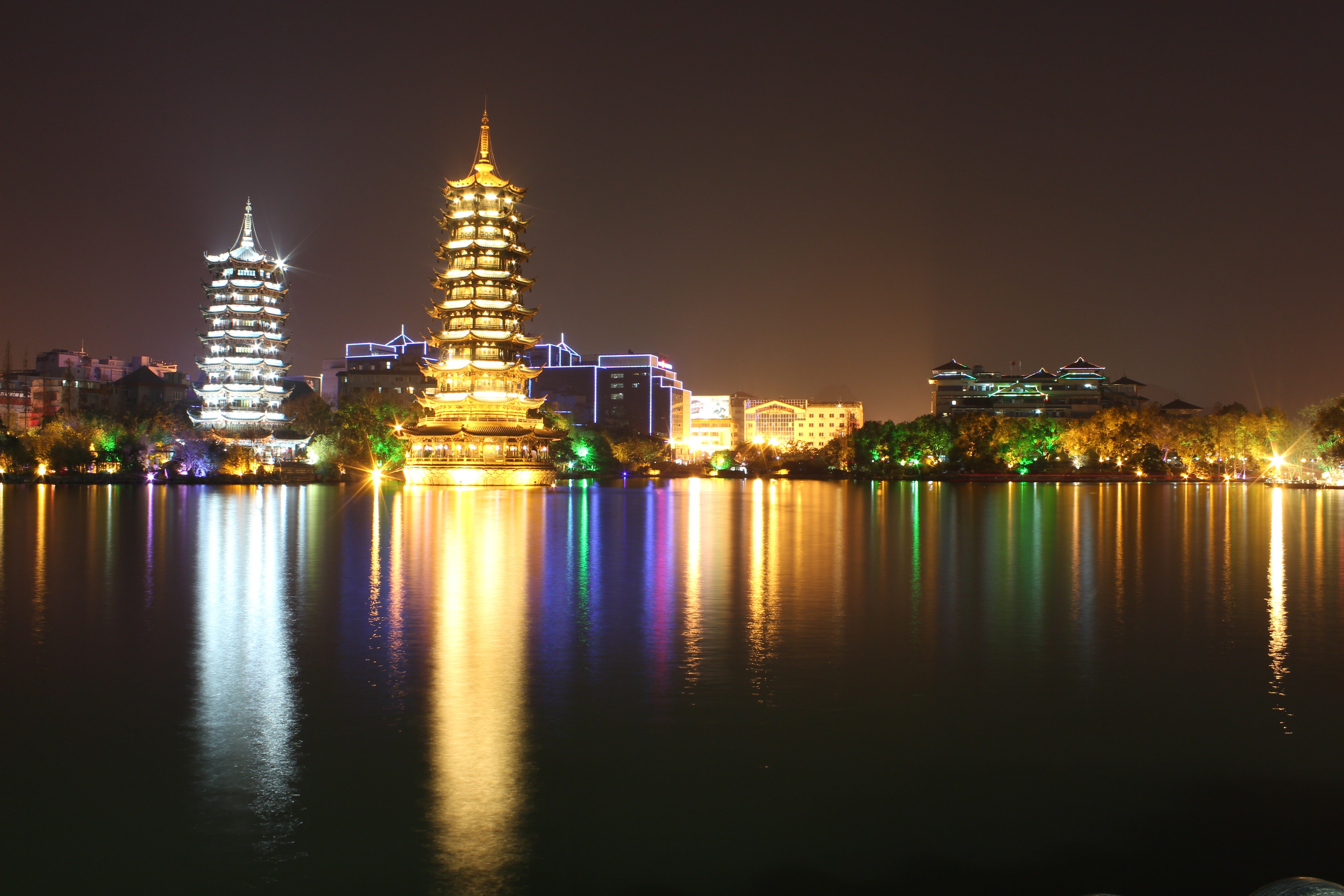 Two pagodas illuminated at night reflected in a lake in Guilin HD Wallpaper