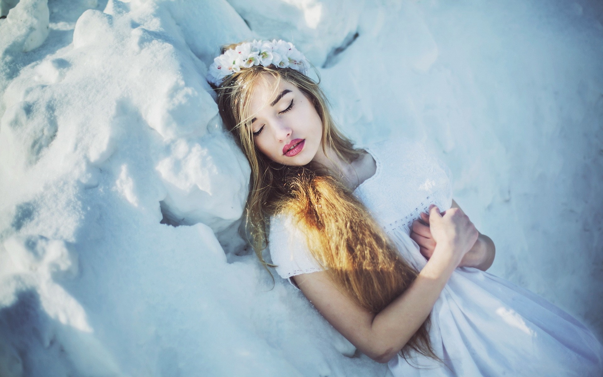Woman with flower crown sleeping in snow HD Wallpaper