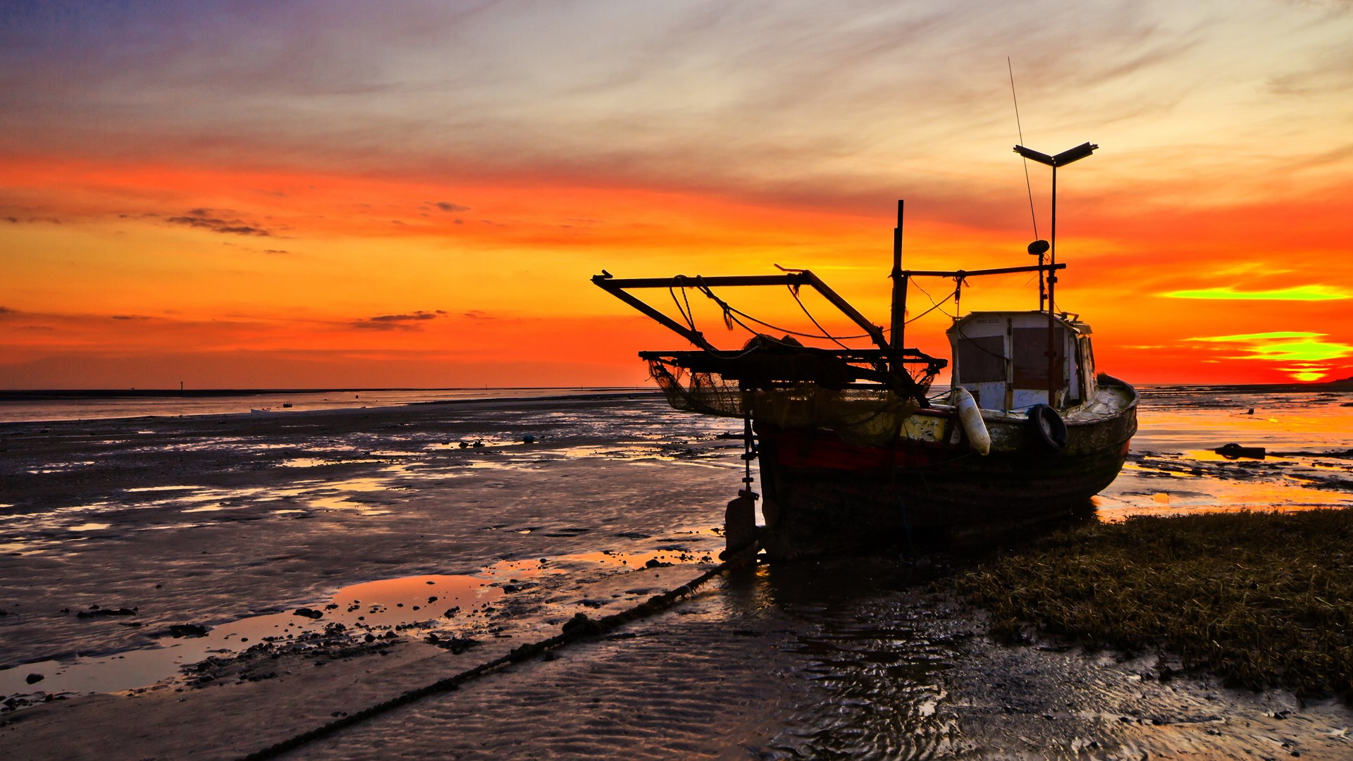 Fishing boat on a beach at sunset HD Wallpaper