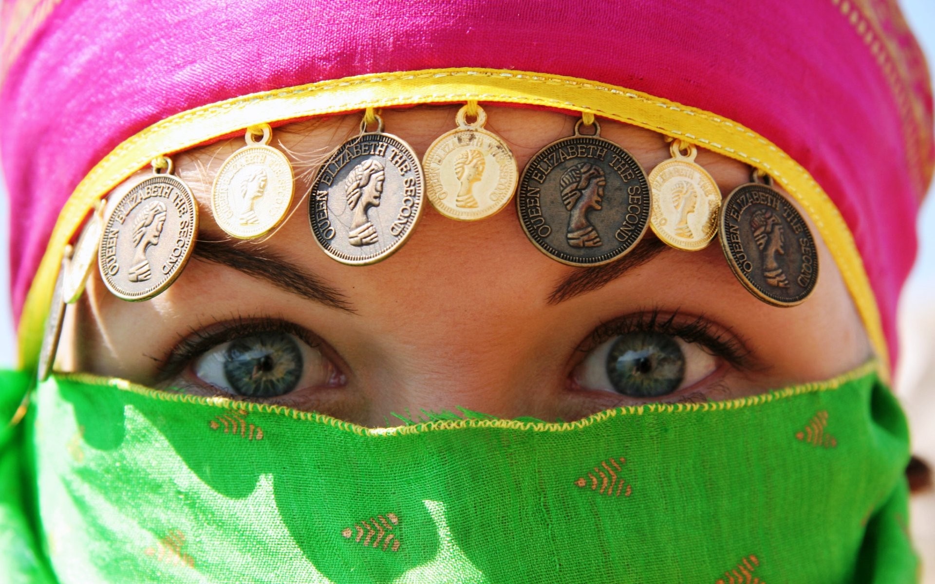Woman wearing a pink headscarf with coins and a green veil HD Wallpaper