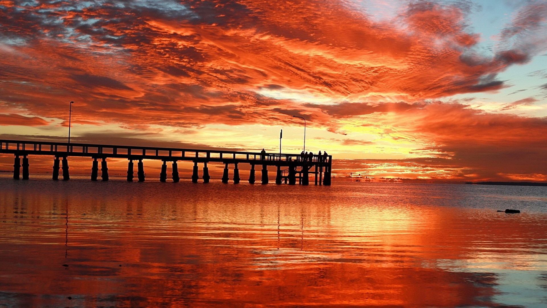 Sunset over a pier with fiery clouds HD Wallpaper