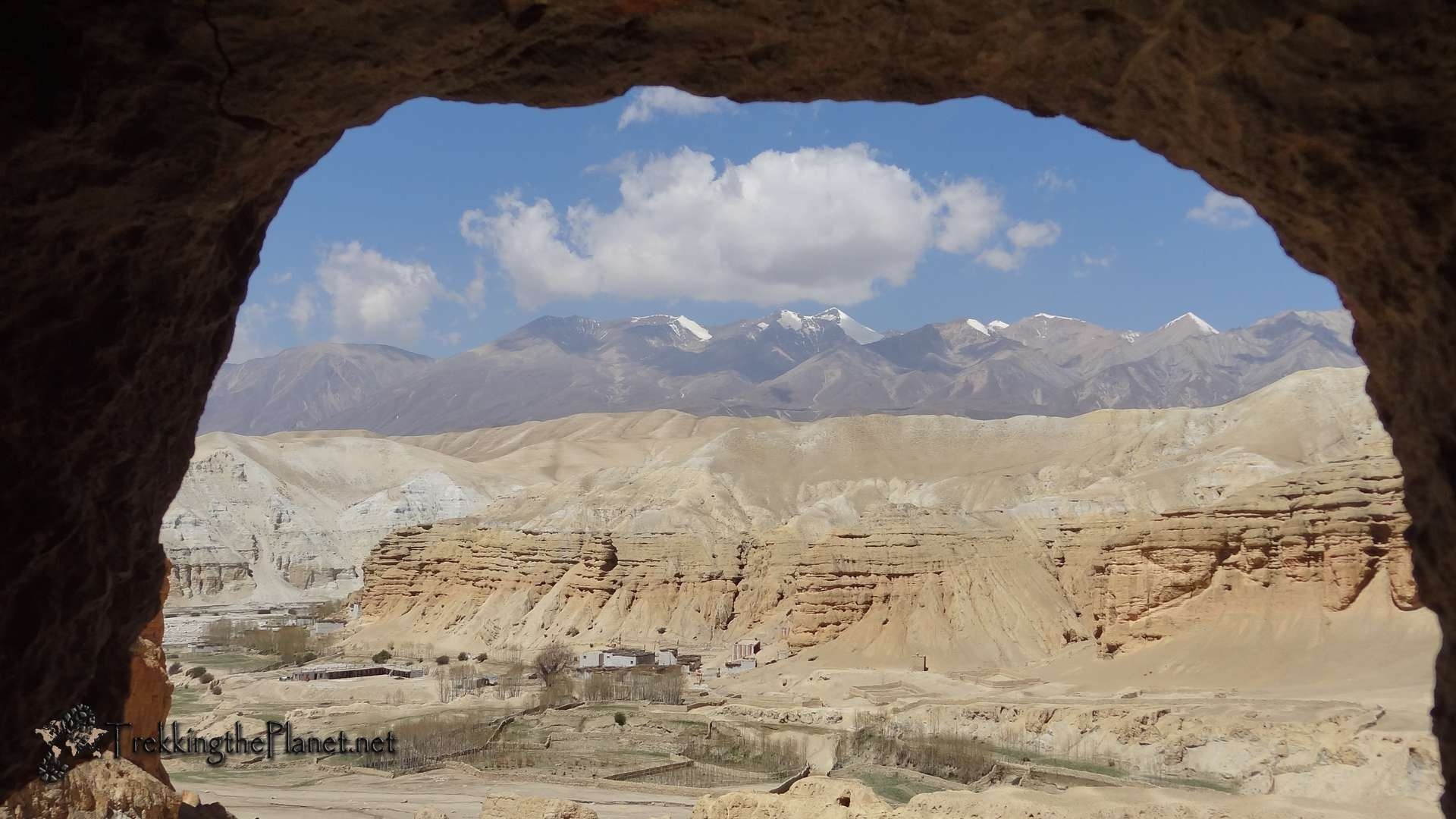 View of a valley and mountains through a rock arch in Nepal HD Wallpaper