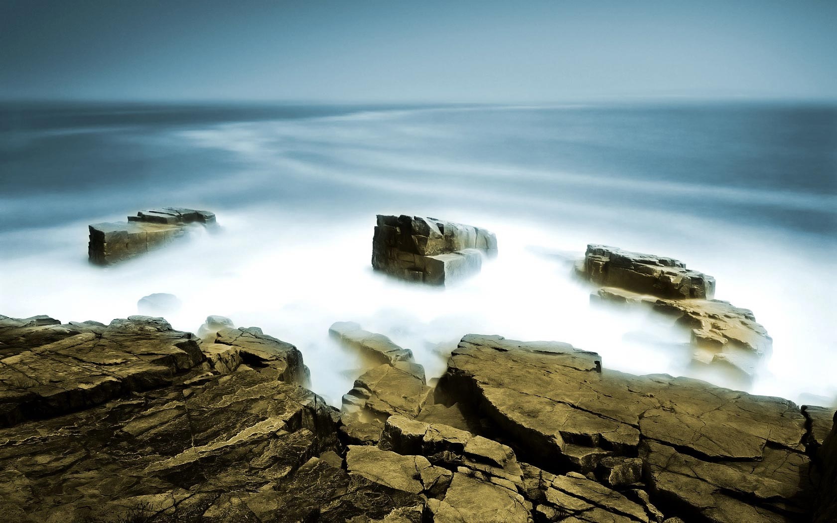 Rocks in the ocean with misty water HD Wallpaper