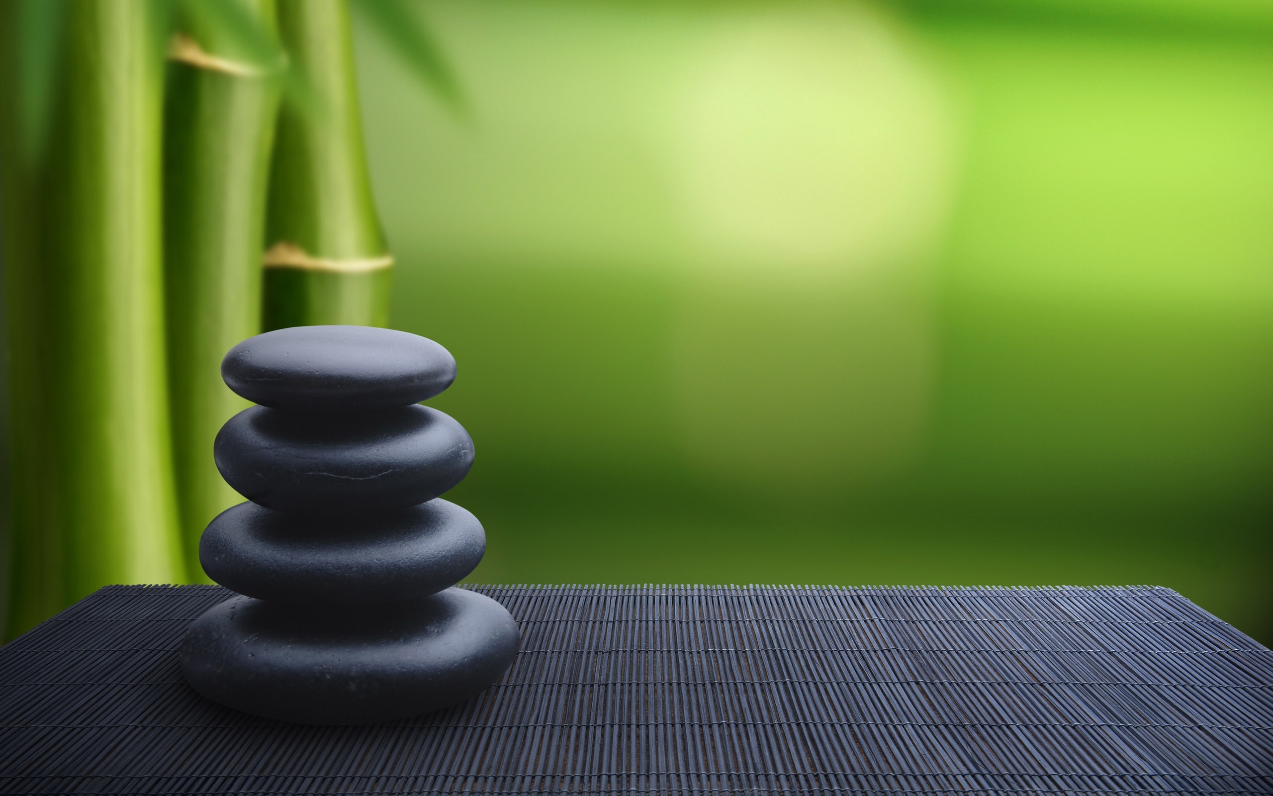 Stacked stones with bamboo and green background HD Wallpaper