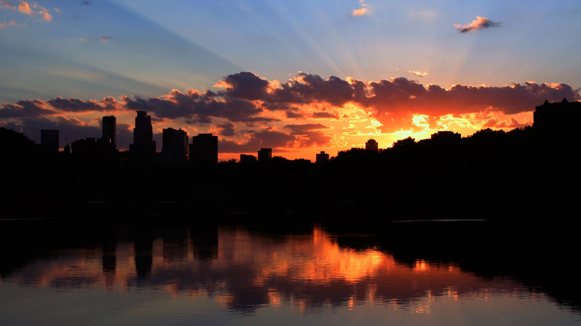 City skyline silhouette at sunset over water HD Wallpaper