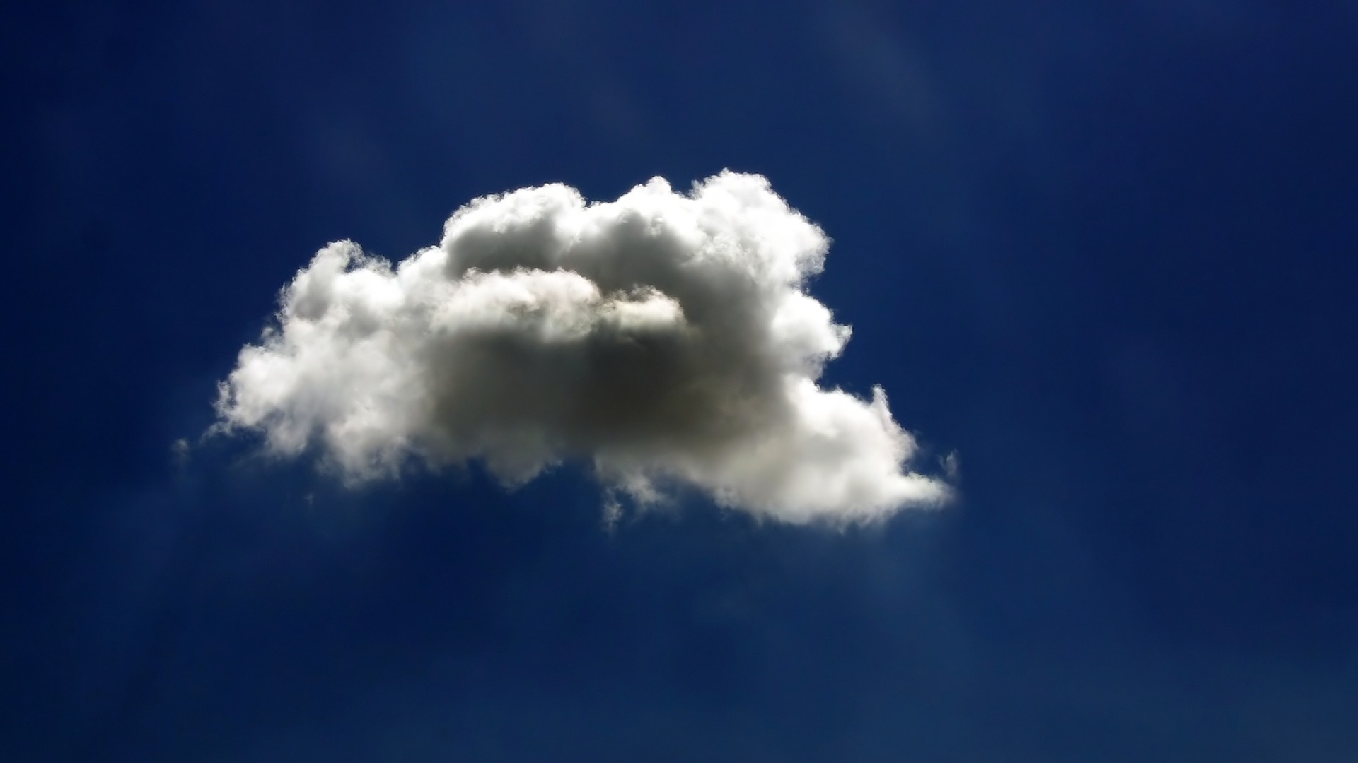 A single cumulus cloud against a deep blue sky HD Wallpaper