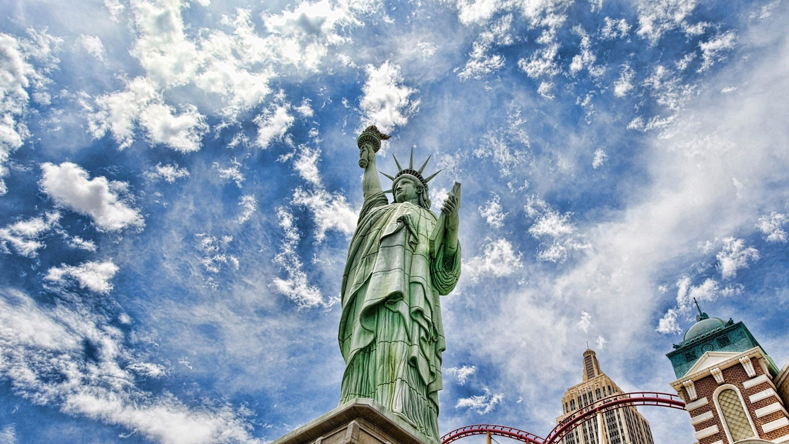 Statue of Liberty replica with roller coaster and skyscrapers HD Wallpaper