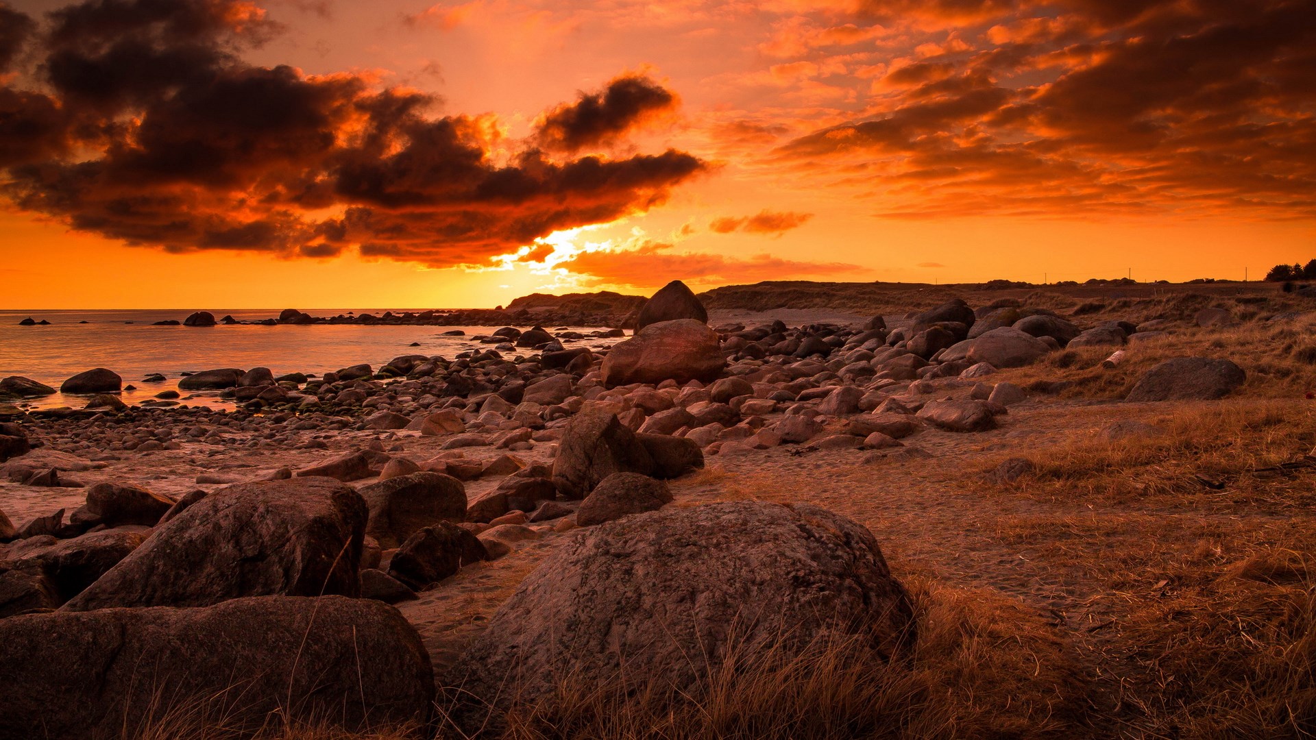 Rocky beach at sunset with dramatic clouds HD Wallpaper