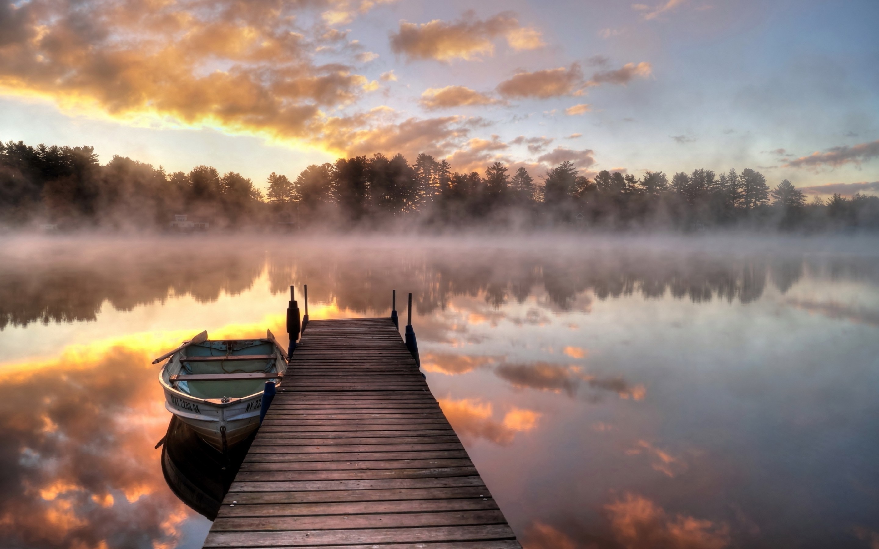 Boat docked on a misty lake at sunrise HD Wallpaper