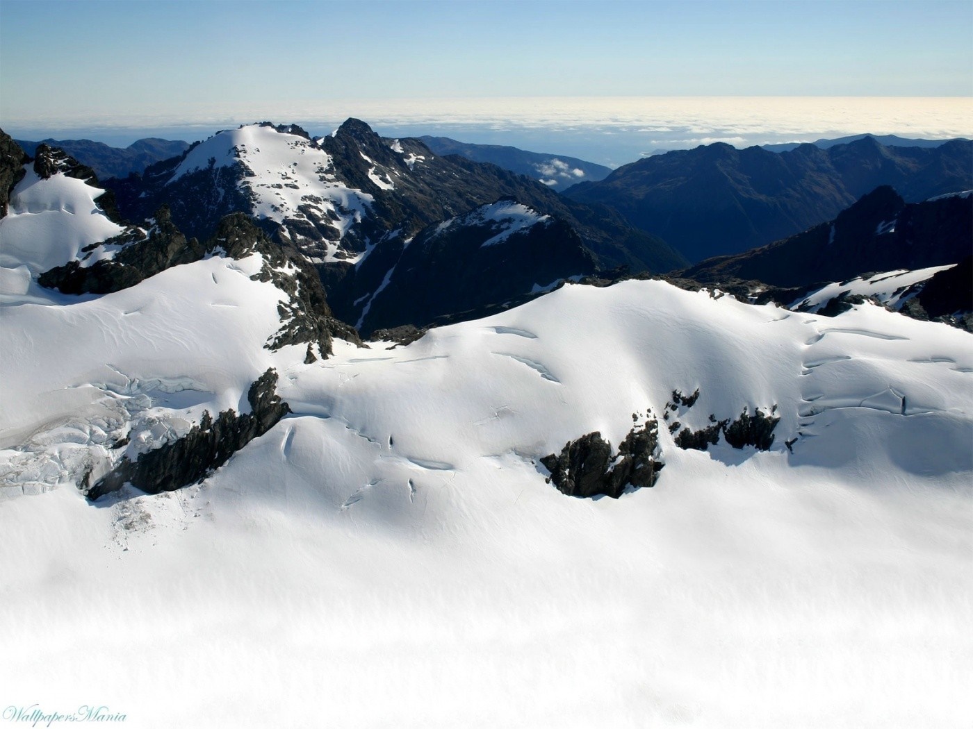 Snow-covered mountains under a clear sky HD Wallpaper