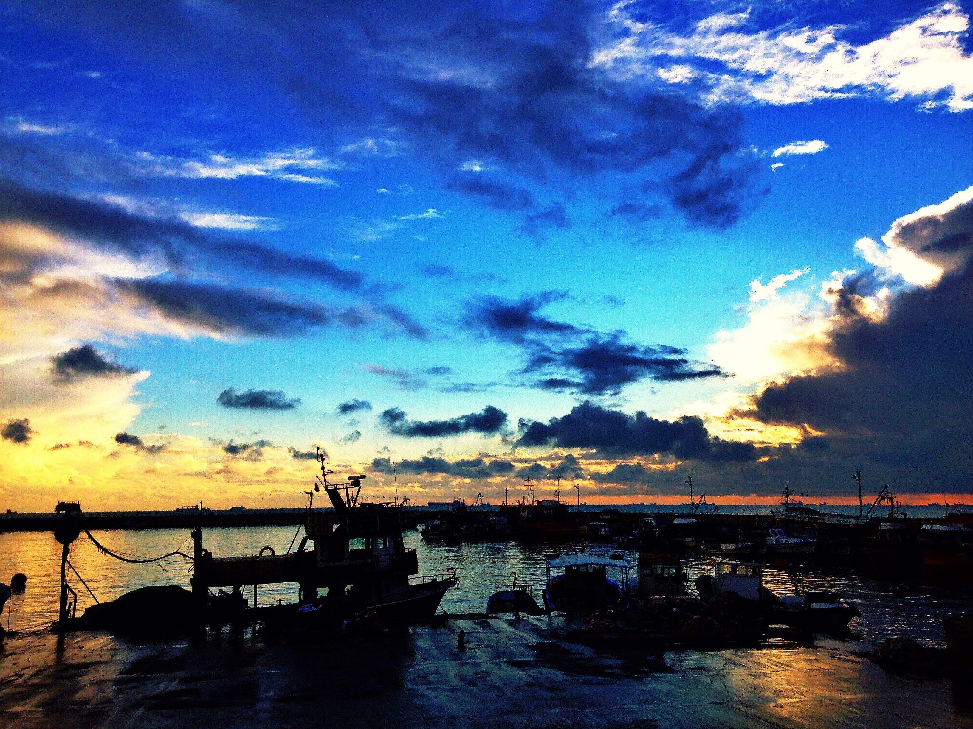 Boats in a harbor at sunset with dramatic clouds HD Wallpaper