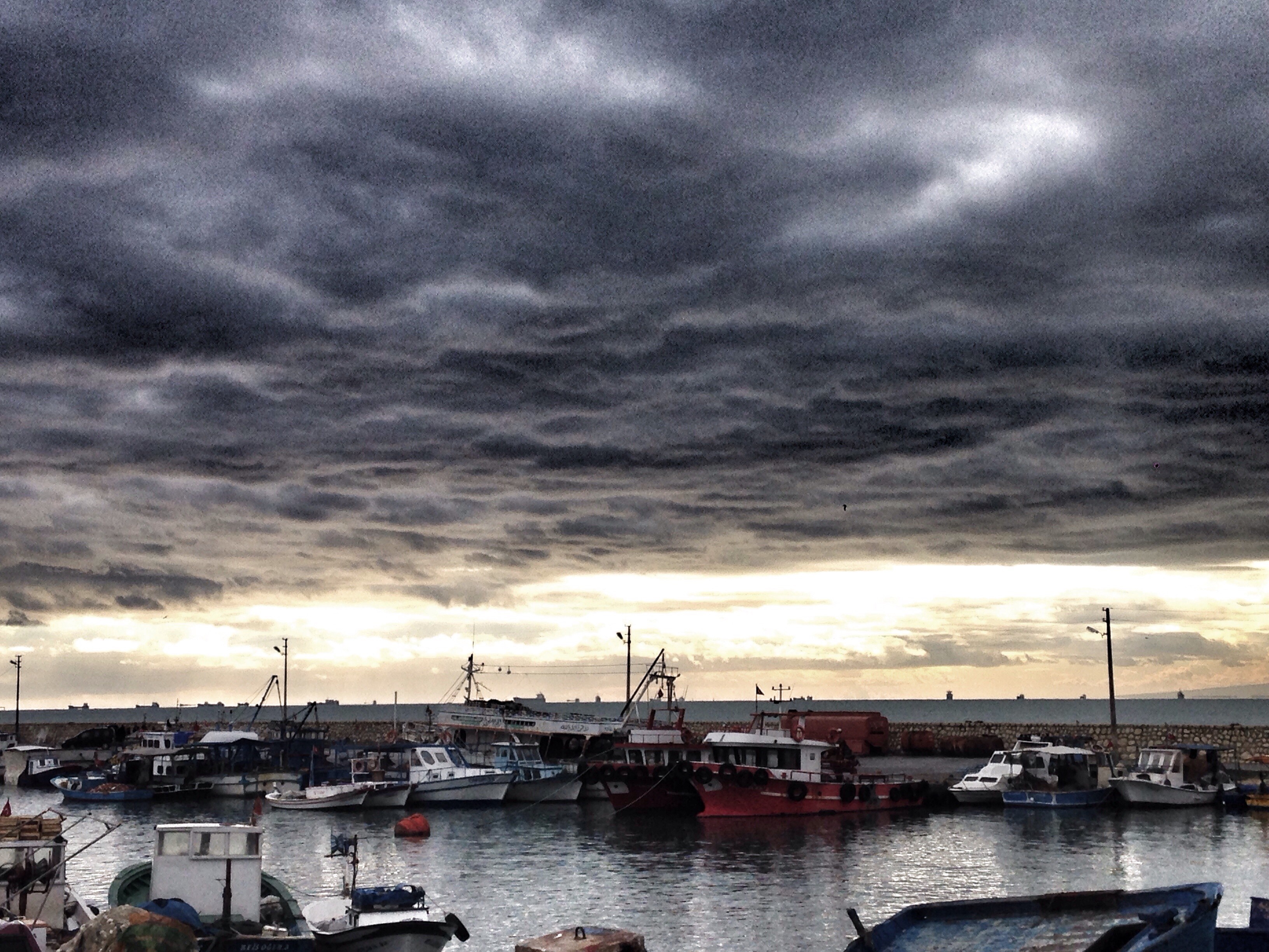 Boats docked in a harbor under stormy clouds HD Wallpaper