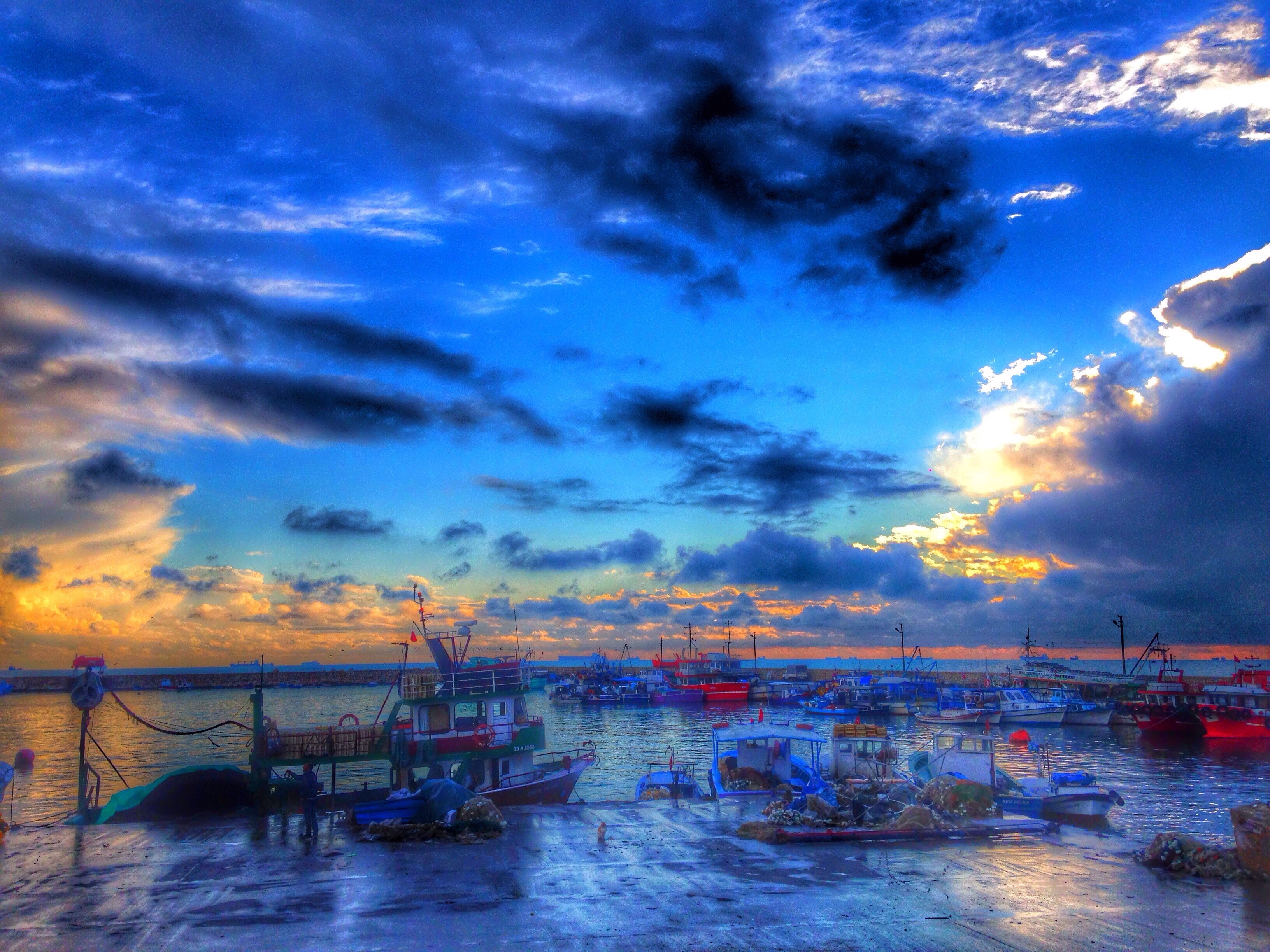 Boats in a harbor at sunset with dramatic clouds HD Wallpaper