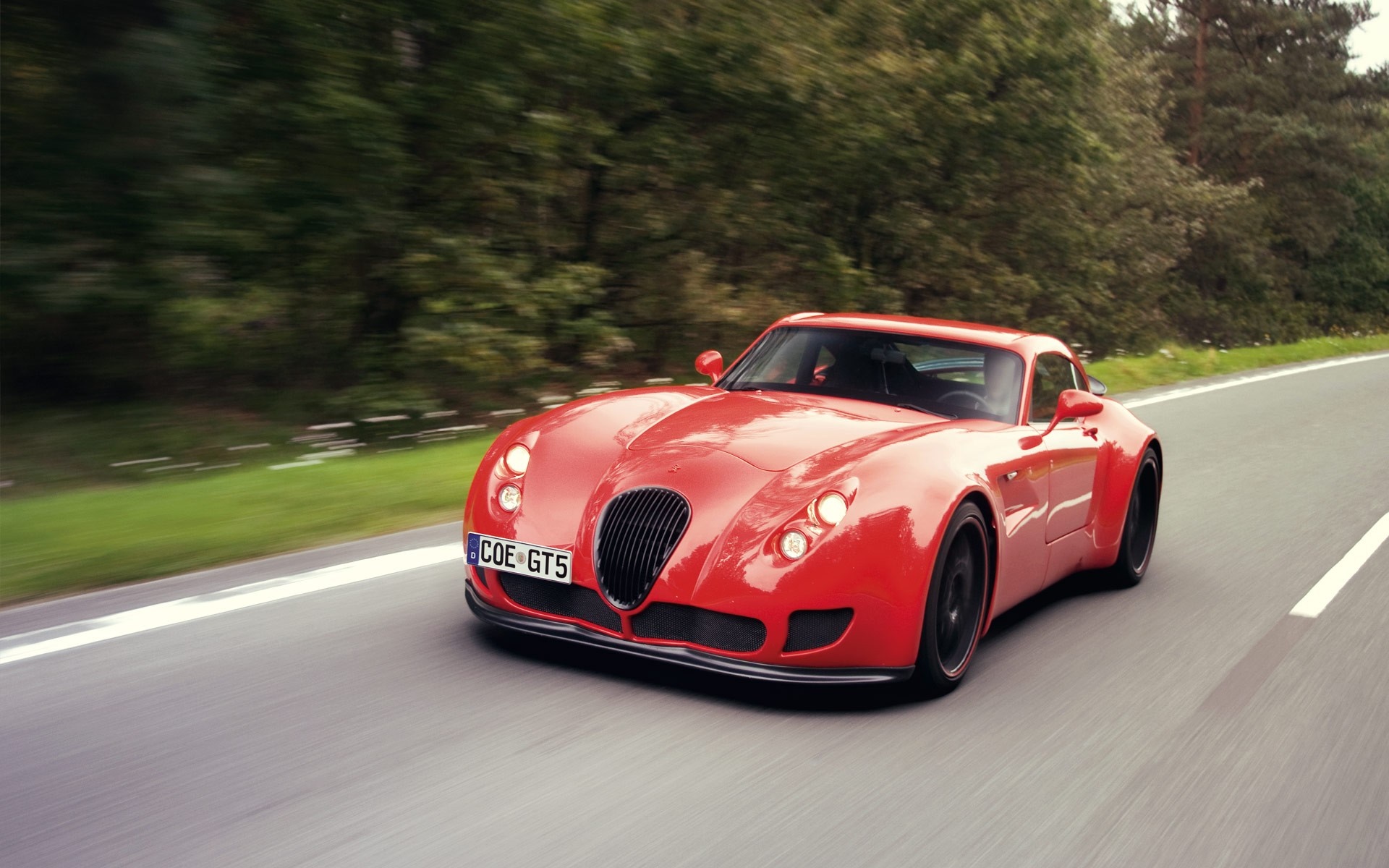 Red Wiesmann GT MF5 sports car driving on a road HD Wallpaper