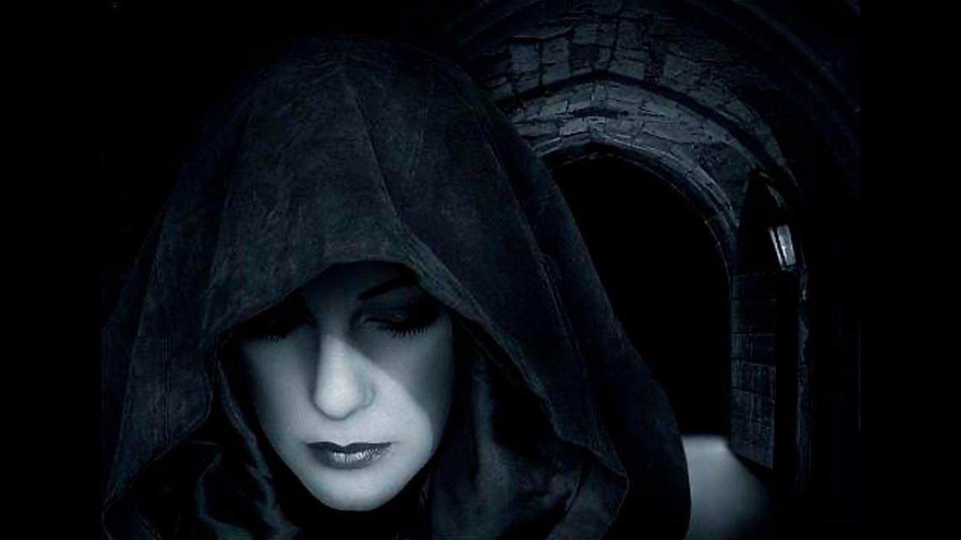 Woman in a black hood in a dark stone archway HD Wallpaper