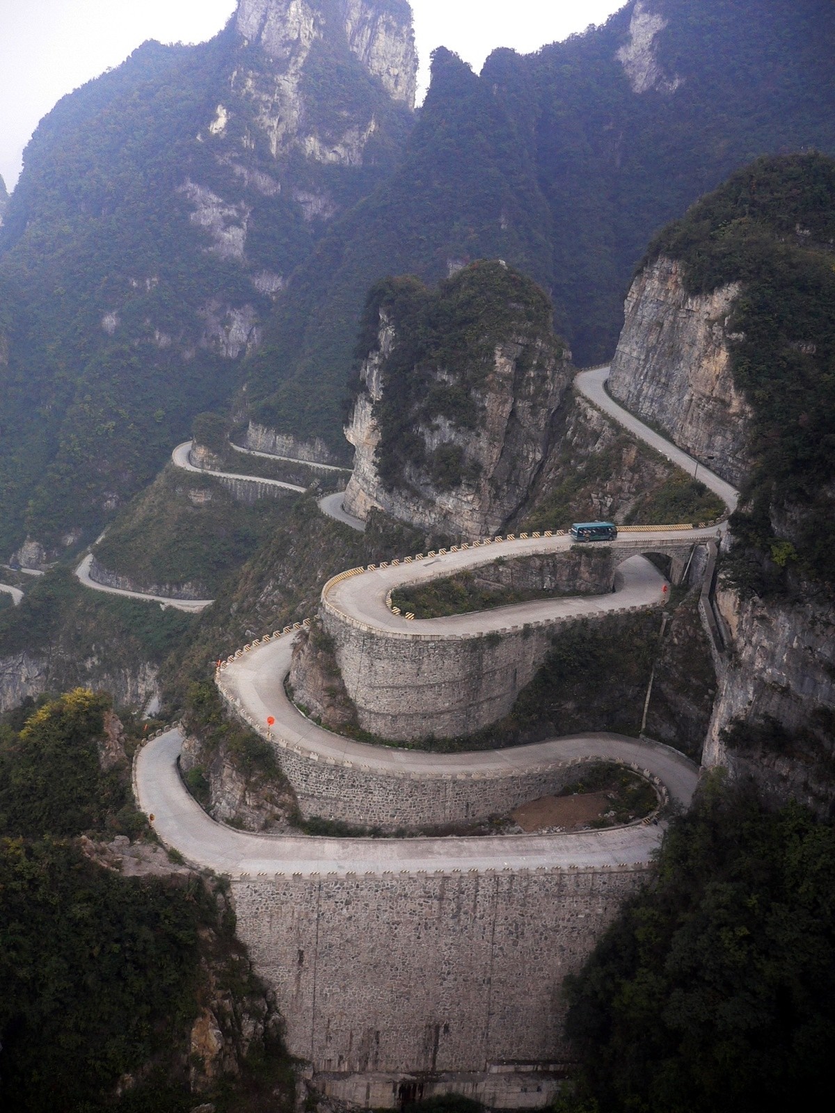 Winding mountain road with a bus HD Wallpaper