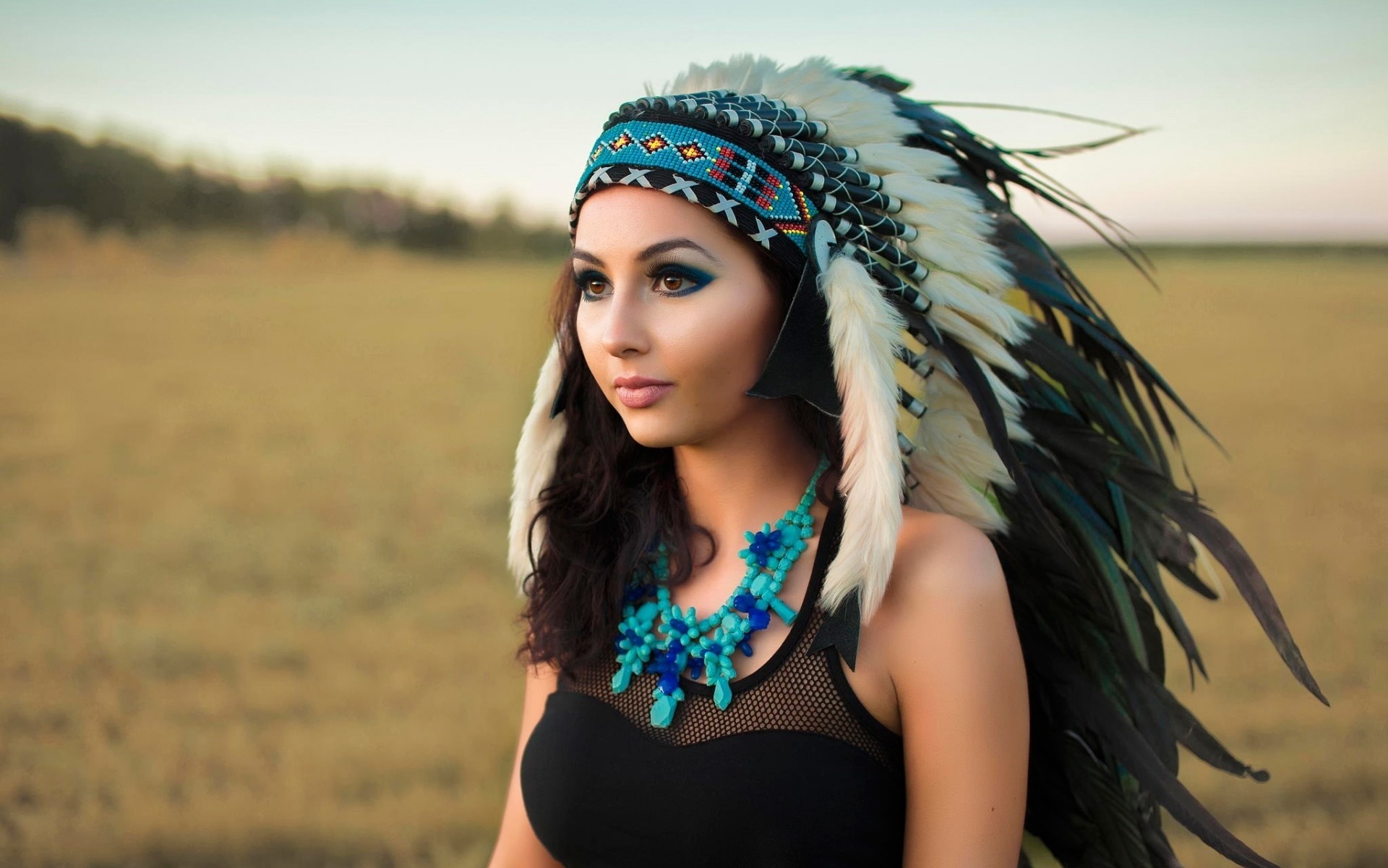 Woman wearing a Native American headdress and blue necklace HD Wallpaper