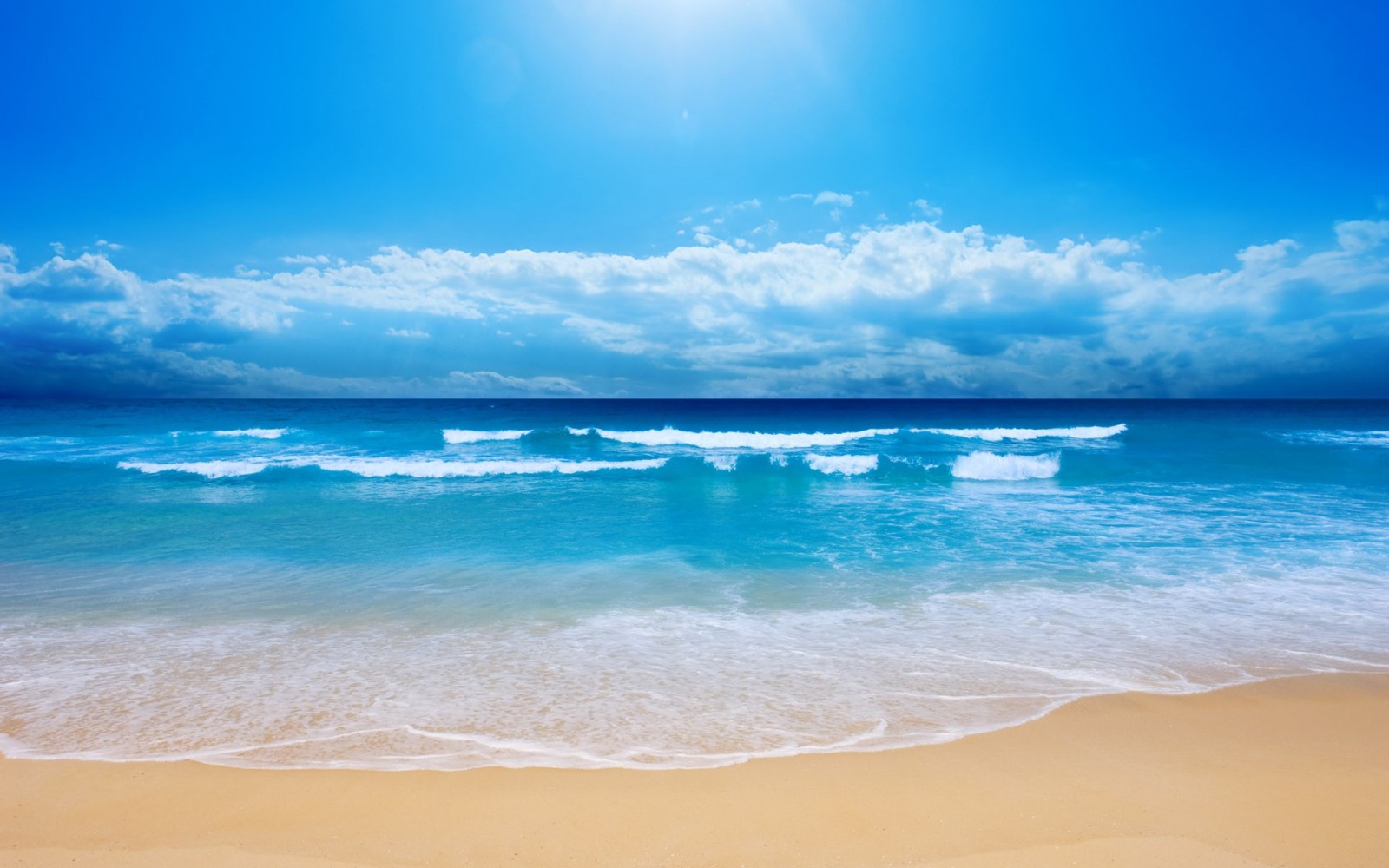 Beach with waves under a blue sky with clouds HD Wallpaper