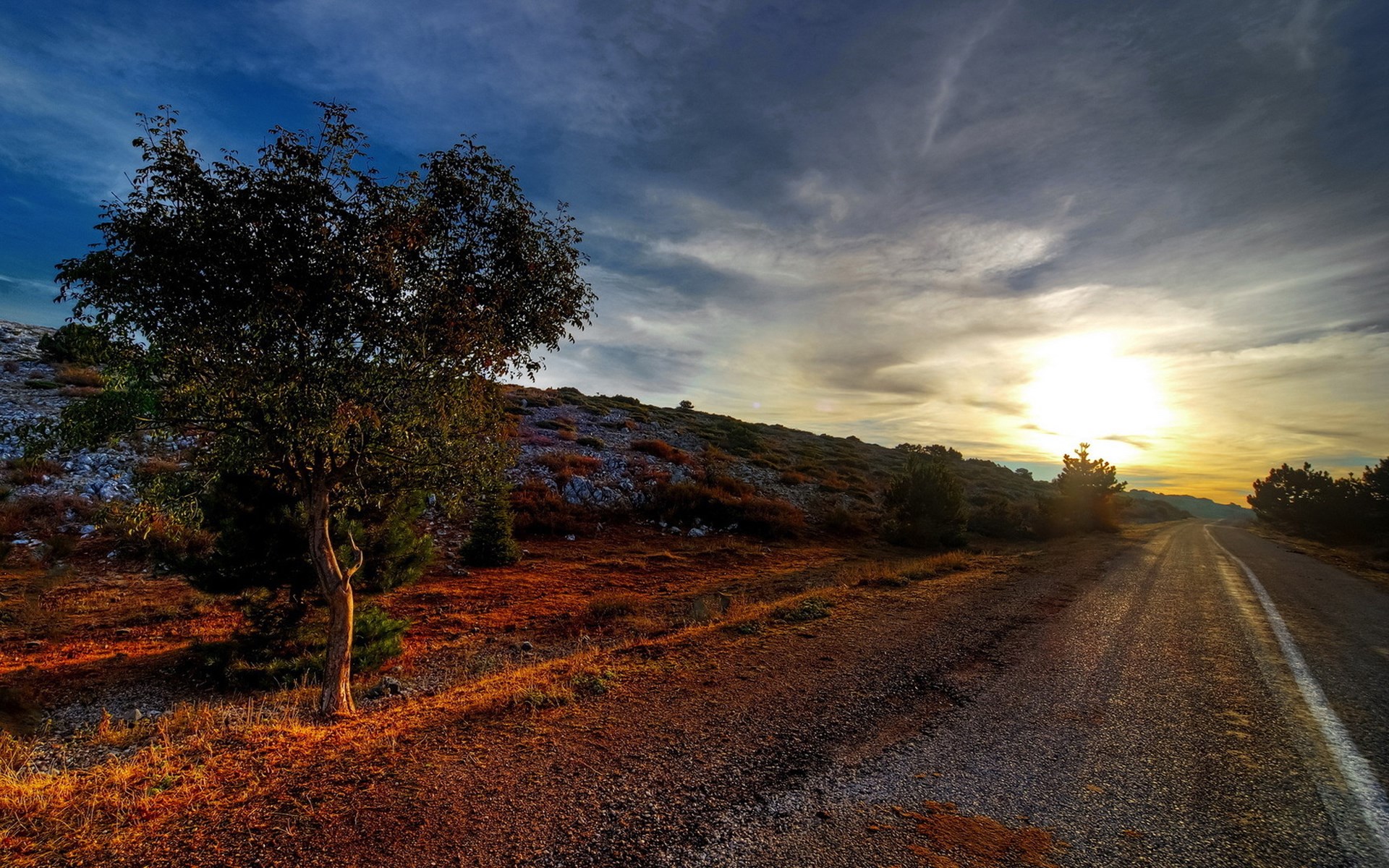 Road through a rocky landscape at sunset HD Wallpaper